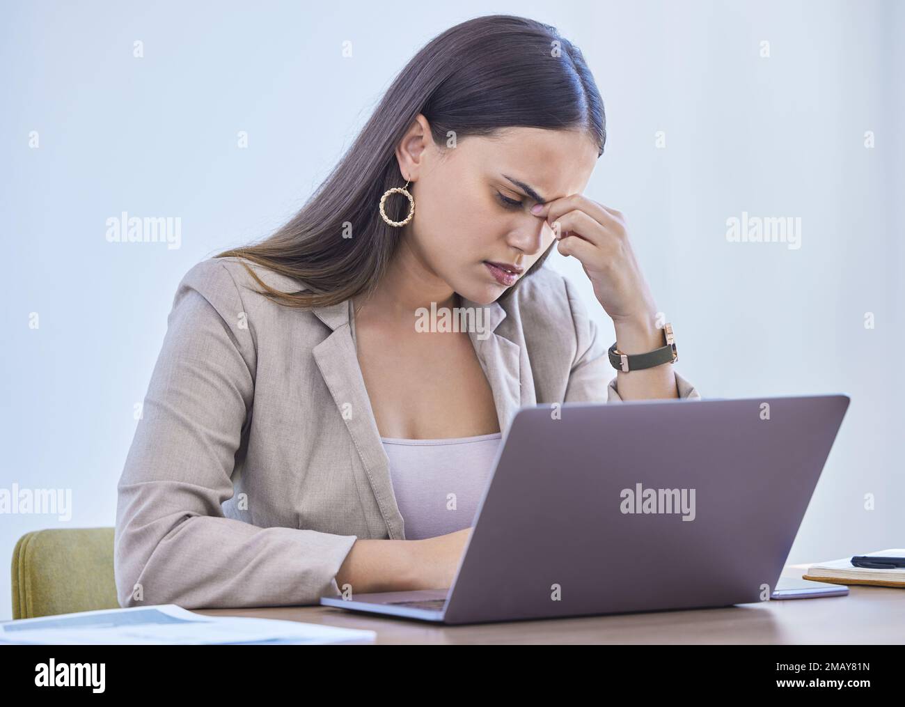 Voici ce mal de tête de tension. une jeune femme d'affaires qui regarde stressée pendant qu'elle travaille dans un bureau. Banque D'Images