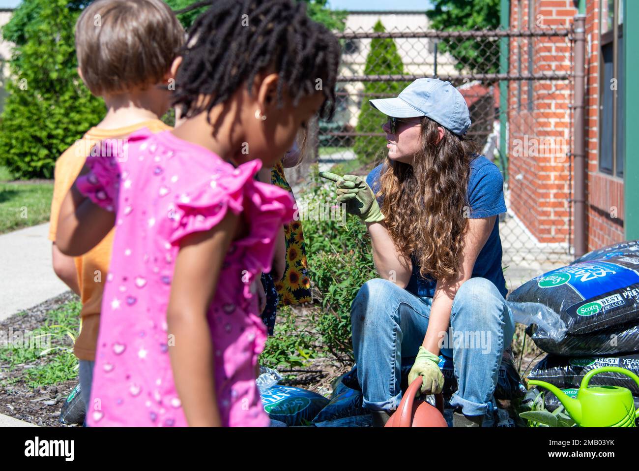 Centre d’approvisionnement de la Défense Nicole Goicochea, chef de la Division de l’environnement de Columbus, s’entretient avec les enfants avant de planter dans le jardin du Centre de développement de l’enfant de Colomb de la DSCC, 8 juin. Sept classes pré-K ont participé à la journée de plantation, mais toutes les classes au centre ont tendance au jardin chaque année. Le jardin est un partenariat conjoint avec la Division de l'environnement de la DSCC et en est à sa sixième saison. Banque D'Images