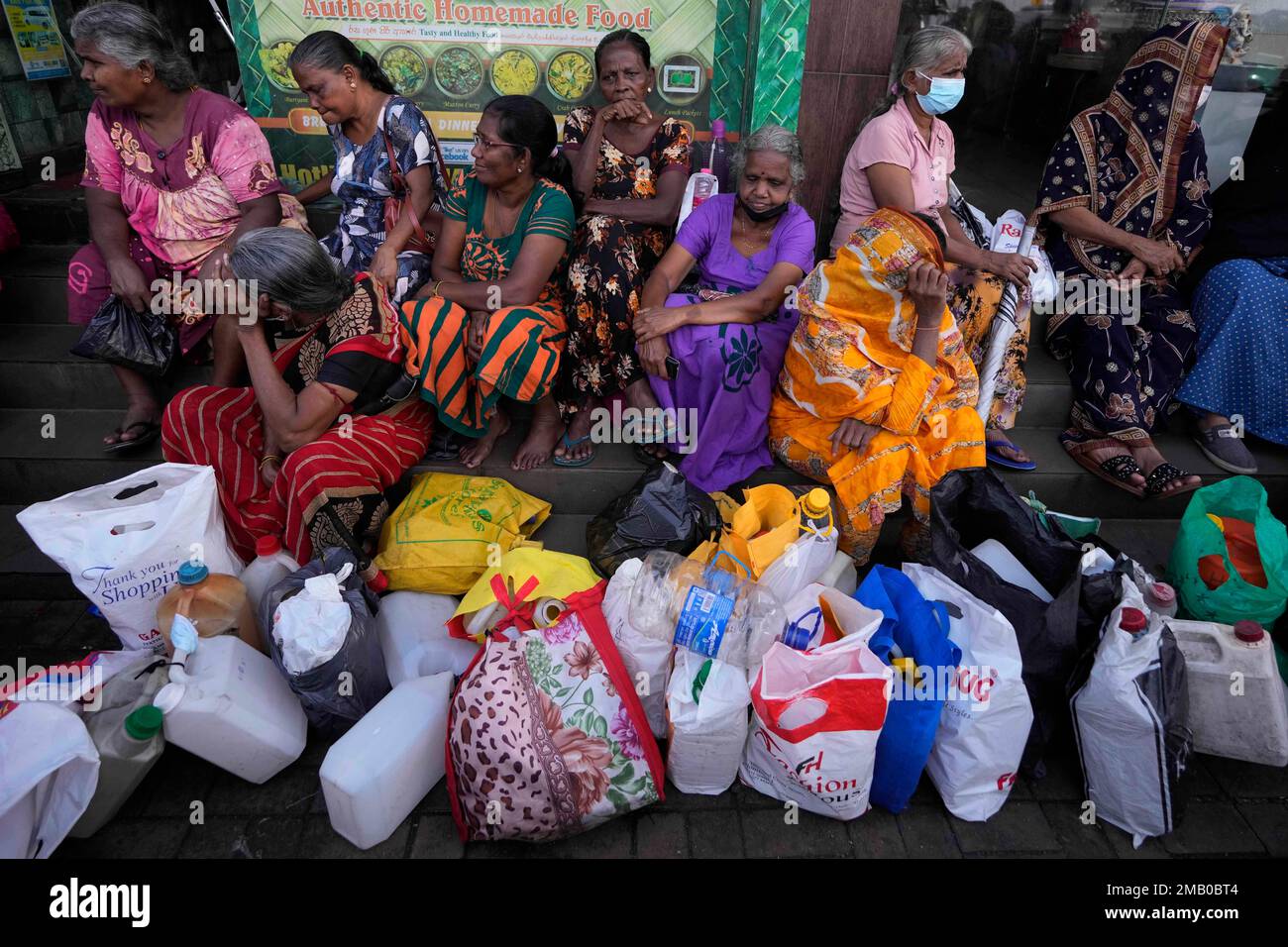 FILE- Women wait near an empty fuel station hoping to buy kerosene oil for cooking in Colombo, Sri Lanka, Thursday, May 26, 2022. Sri Lankan President Ranil Wickremesinghe said Saturday, July 30, that an agreement with the International Monetary Fund to help pull the bankrupt nation out of its economic crisis is pushed back to September because of unrest over the past weeks. (AP Photo/Eranga Jayawardena, File) Banque D'Images