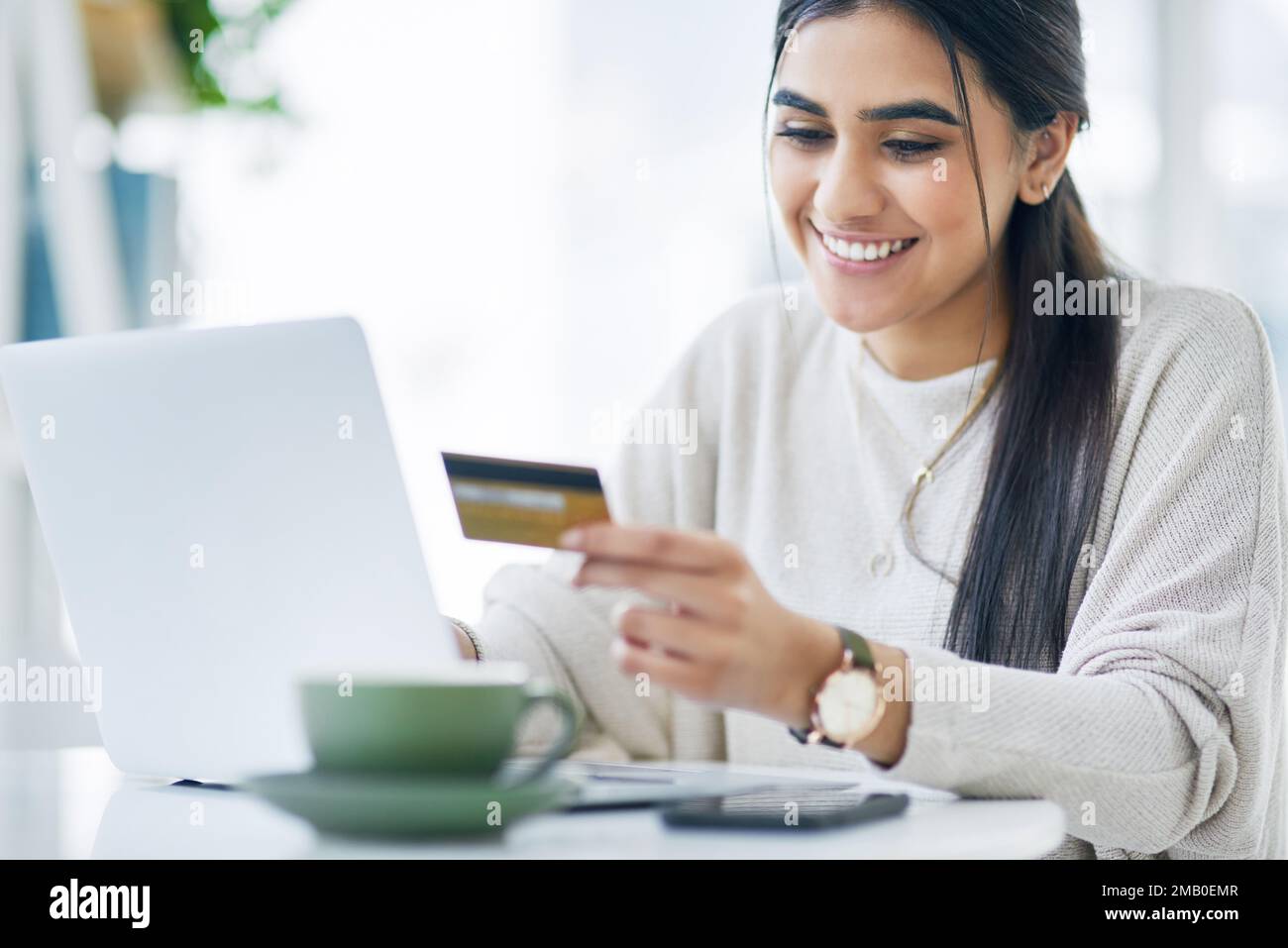 Transférez de l'argent rapidement quand vous en avez besoin. une jeune femme d'affaires utilisant un ordinateur portable et une carte de crédit dans un bureau. Banque D'Images