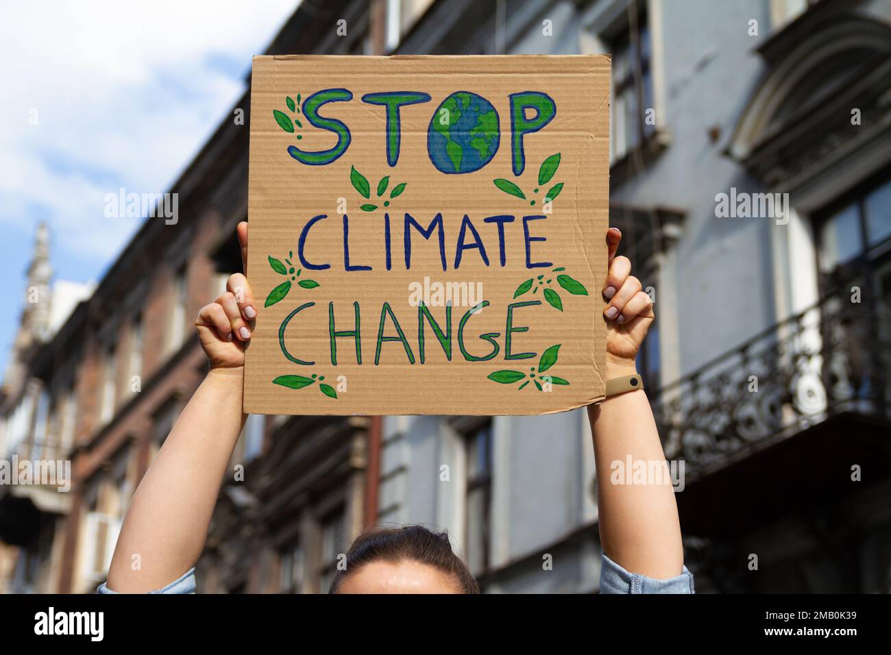 Un manifestant tient un panneau Stop au changement climatique. Femme avec plaque à la manifestation de rassemblement de protestation, grève contre le réchauffement de la planète. Banque D'Images