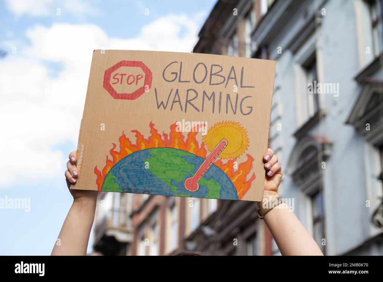 Un manifestant tient un signe avec le slogan Stop Global Warming. Femme avec plaque à la manifestation de rassemblement de protestation, grève contre le changement climatique. Banque D'Images