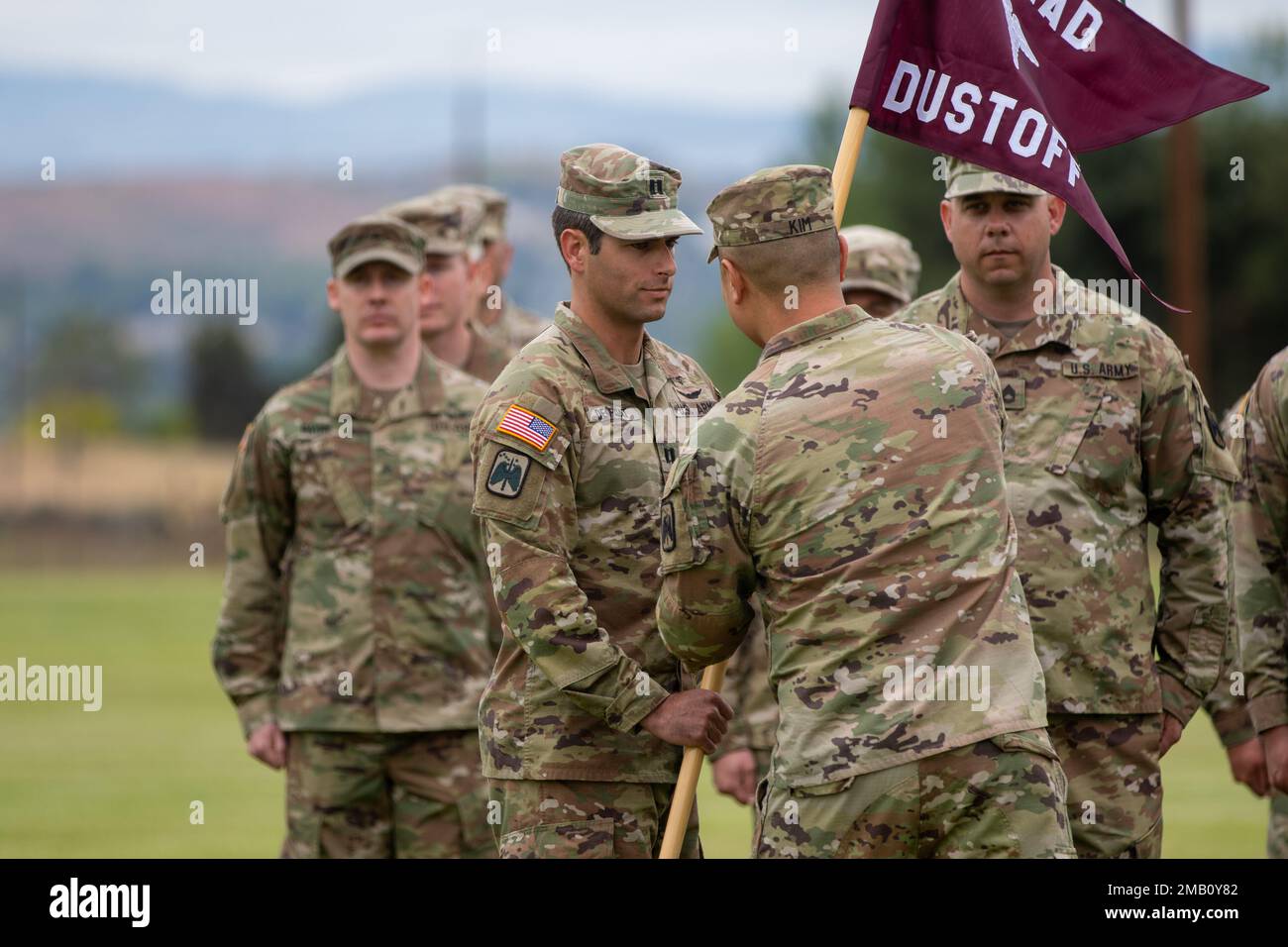 Capt. Alec DeGroat, commandant entrant des États-Unis Le détachement d'ambulance aérienne de l'Armée de terre Yakima, 2-158 Bataillon des hélicoptères d'assaut, 16th Brigade de l'aviation de combat reçoit l'aide du commandant du bataillon Lt. Colonel Simon Kim lors de la cérémonie de changement de commandement du détachement au Centre d'entraînement de Yakima, Washington, le 9 juin 2022. Banque D'Images