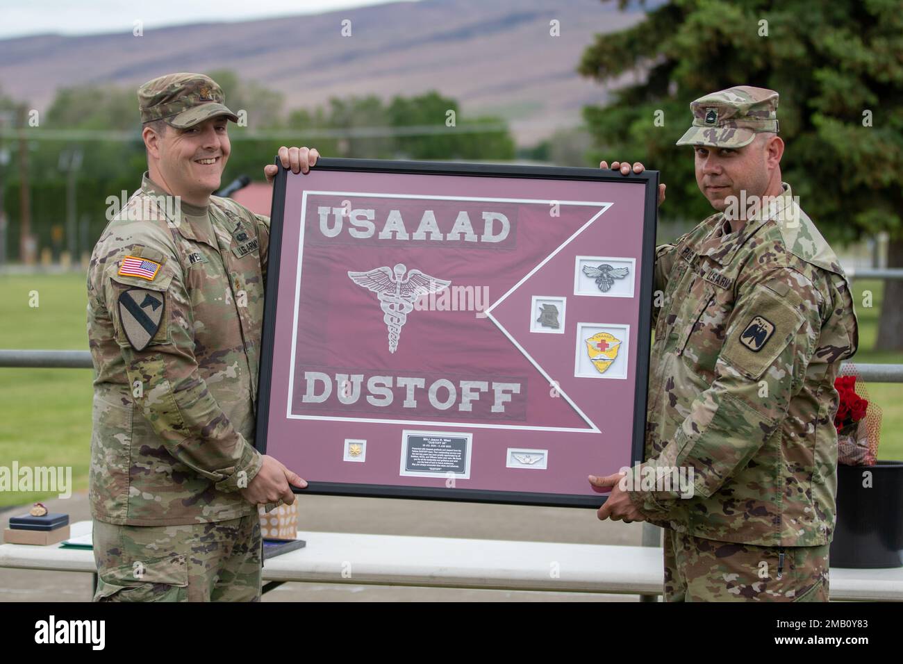 Le Maj. Jason West, commandant sortant des États-Unis Le détachement d'ambulance aérienne de l'Armée de terre Yakima, 2-158 Bataillon des hélicoptères d'assaut, 16th Brigade de l'aviation de combat reçoit un cadeau de ses soldats avant la cérémonie de changement de commandement du détachement au Centre d'entraînement de Yakima, Washington, le 9 juin 2022. Banque D'Images