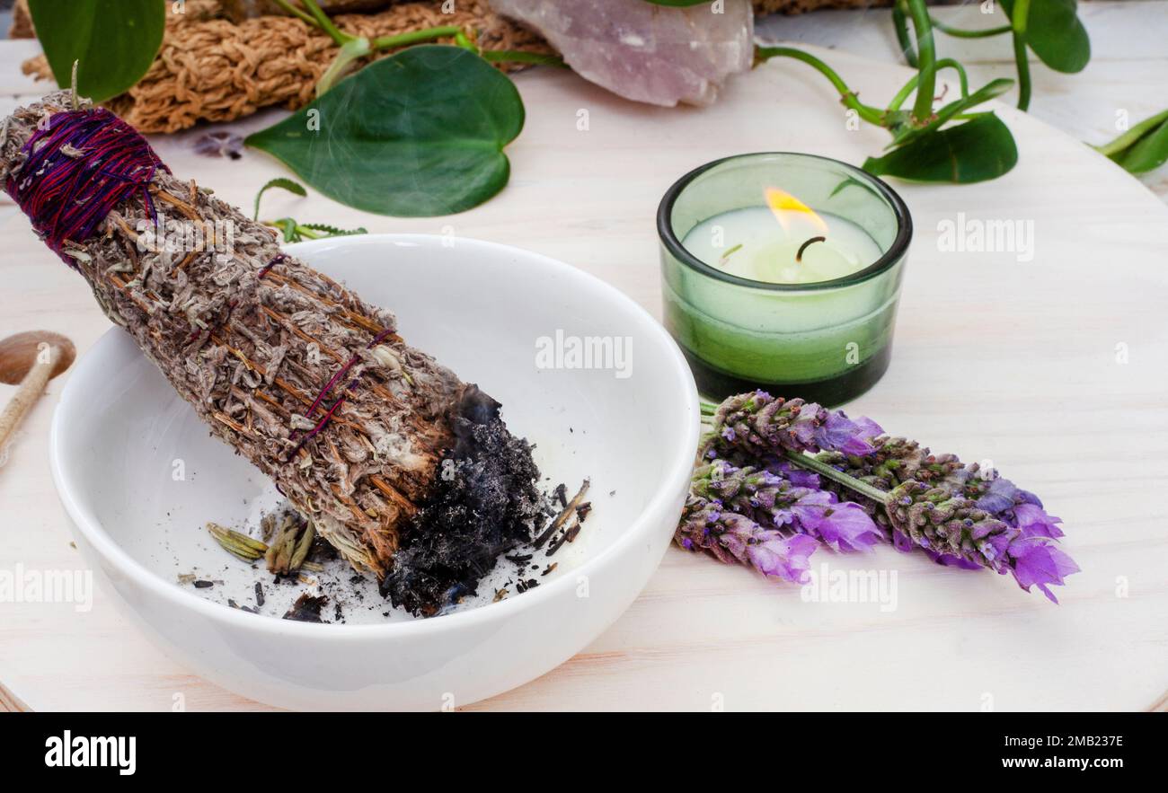 Bâton à taches de bougie et de lavande sur une table avec des plantes et des cristaux Banque D'Images