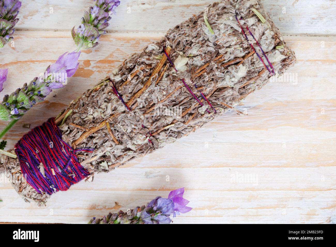 Bâton à taches de bougie et de lavande sur une table avec des plantes et des cristaux Banque D'Images