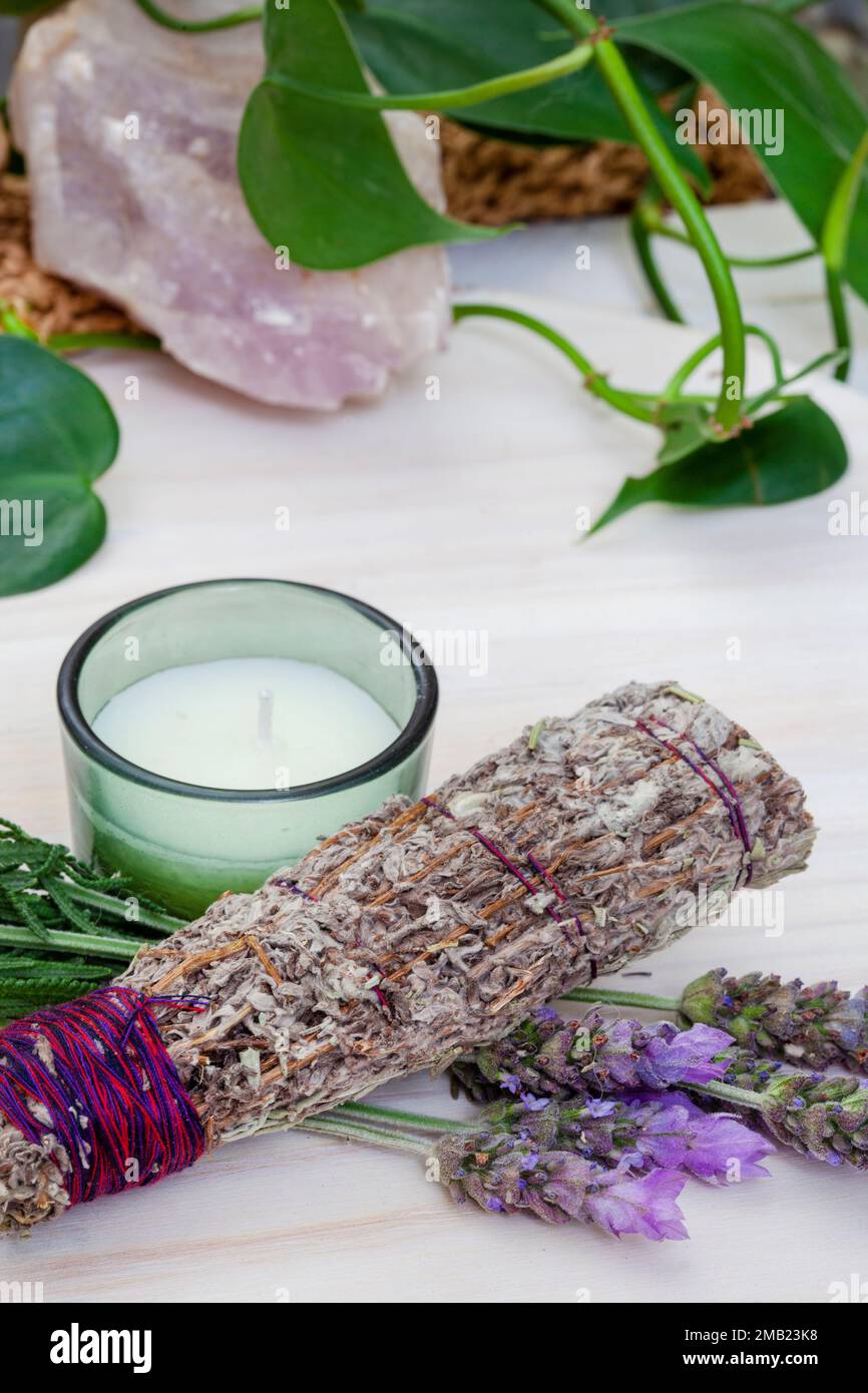 Bâton à taches de bougie et de lavande sur une table avec des plantes et des cristaux Banque D'Images