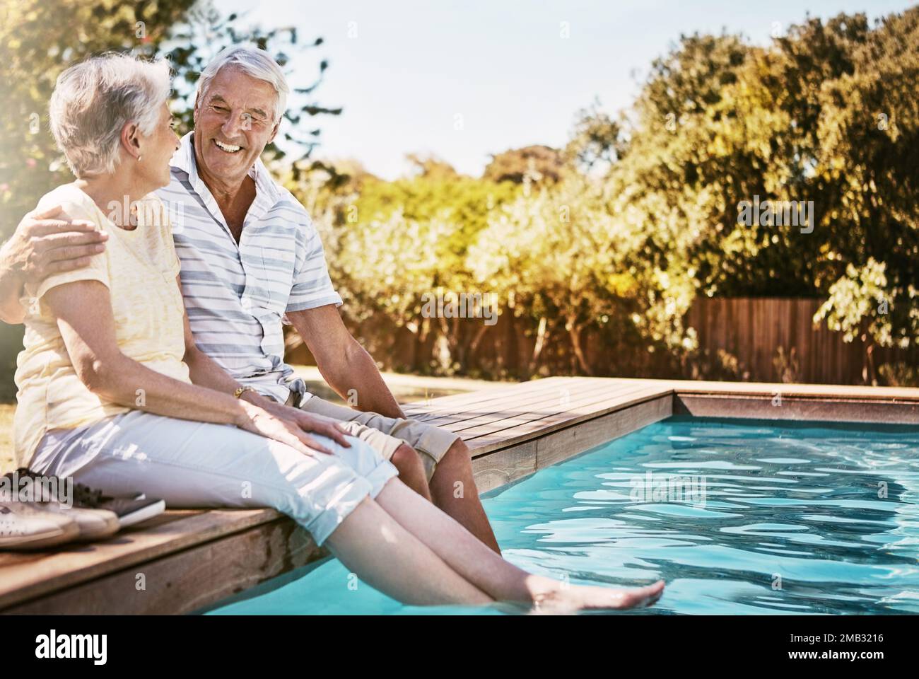 Couple senior, câlin et détendez-vous au bord de la piscine pour l'amour ou le temps de collage de qualité ensemble pendant les vacances d'été. Joyeux homme âgé tenant une femme se détendant Banque D'Images