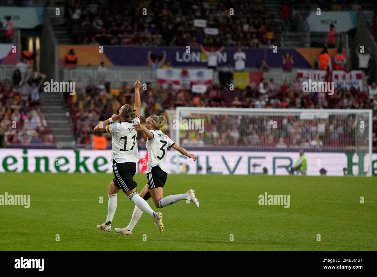 Germany's Alexandra Popp, left, celebrates with Kathrin-Julia Hendrich after scoring her side's second goal during the Women Euro 2022 group B soccer match between Germany and Spain at Brentford Community Stadium in London, England, Tuesday, July 12, 2022. (AP Photo/Alessandra Tarantino) Banque D'Images