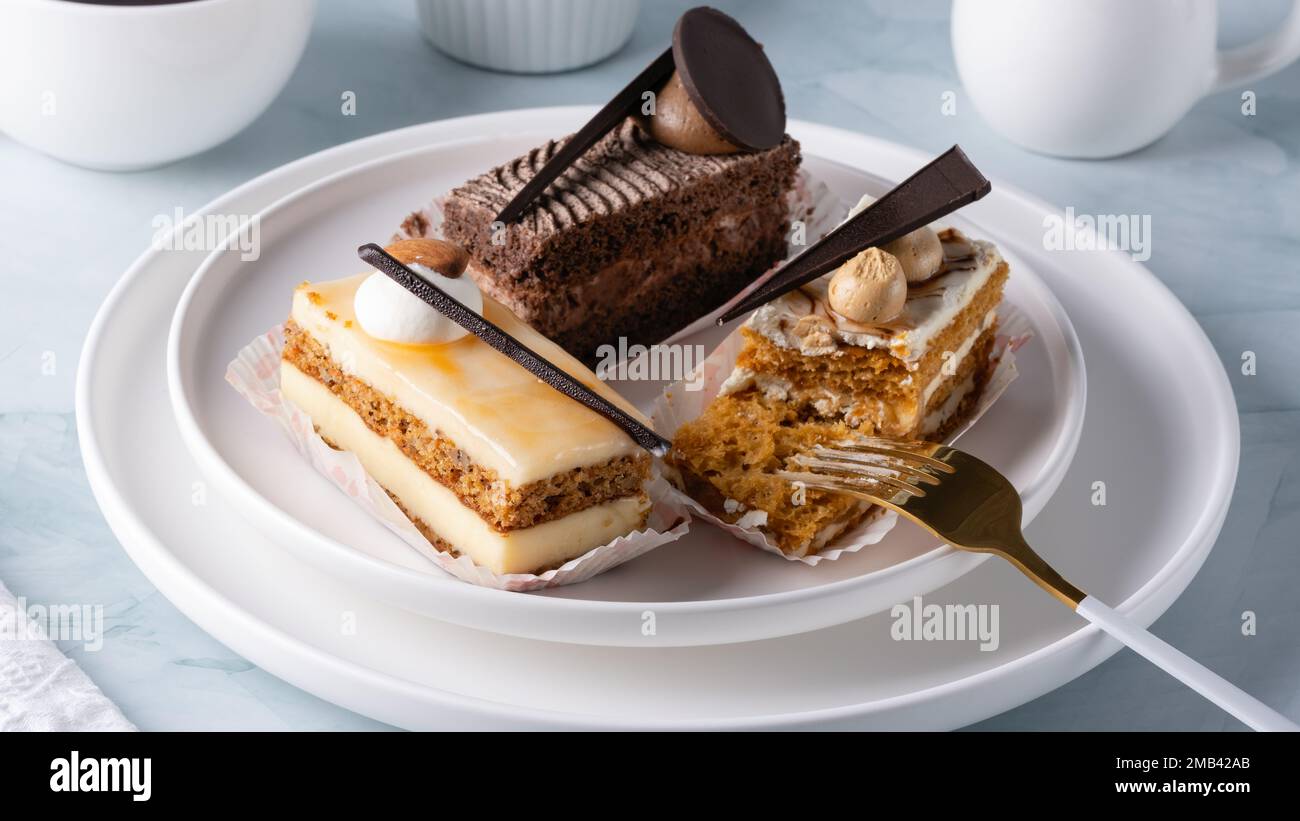 Un ensemble de délicieux gâteaux et café sur une table légère Banque D'Images