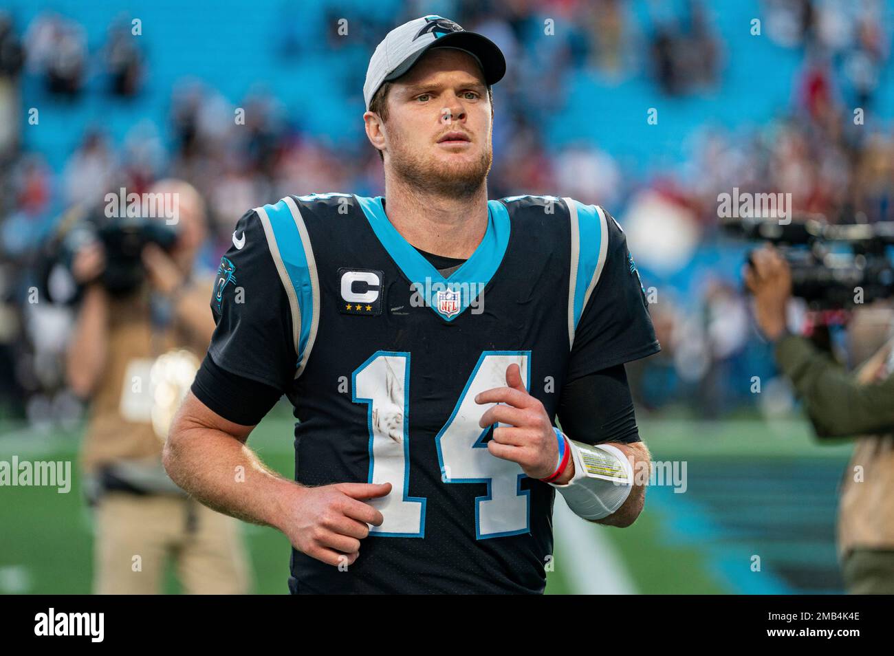 FILE - Carolina Panthers quarterback Sam Darnold (14) walks off the field after a loss to the Tampa Bay Buccaneers after an NFL football game Sunday, Dec. 26, 2021, in Charlotte, N.C. The Panthers view their starting QB job as an open competition between the newly acquired Baker Mayfield and incumbent Sam Darnold, one that will ultimately be decided at training camp and in preseason games.(AP Photo/Jacob Kupferman, File) Banque D'Images
