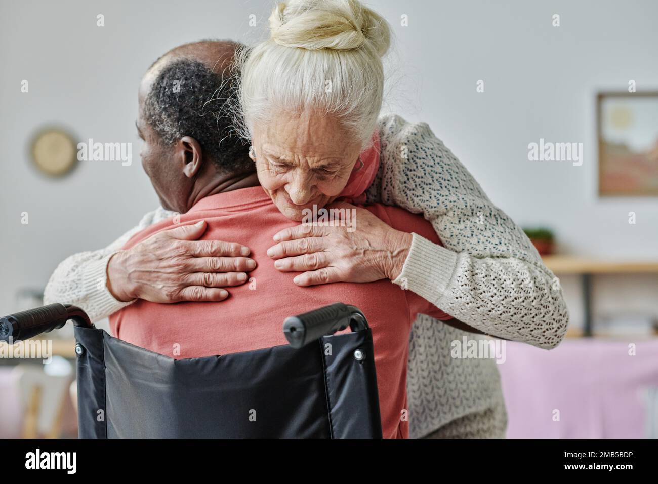 Femme âgée embrassant un homme handicapé pendant un traitement d'embrasage Banque D'Images