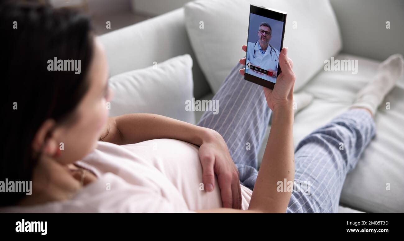 Femme enceinte utilisant un appel vidéo en ligne avec Doctor sur un téléphone mobile Banque D'Images