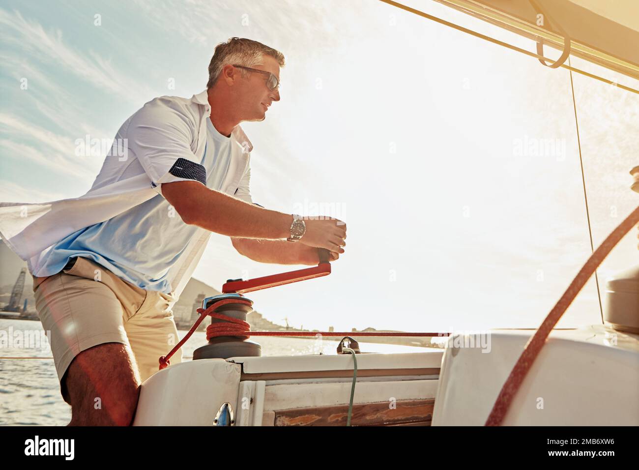 Retraite, yacht de luxe et investissement pour homme mature et treuil à voile dans le contrôle de mât, la gestion du vent ou la vitesse. Personne, bateau de tourisme et corde Banque D'Images