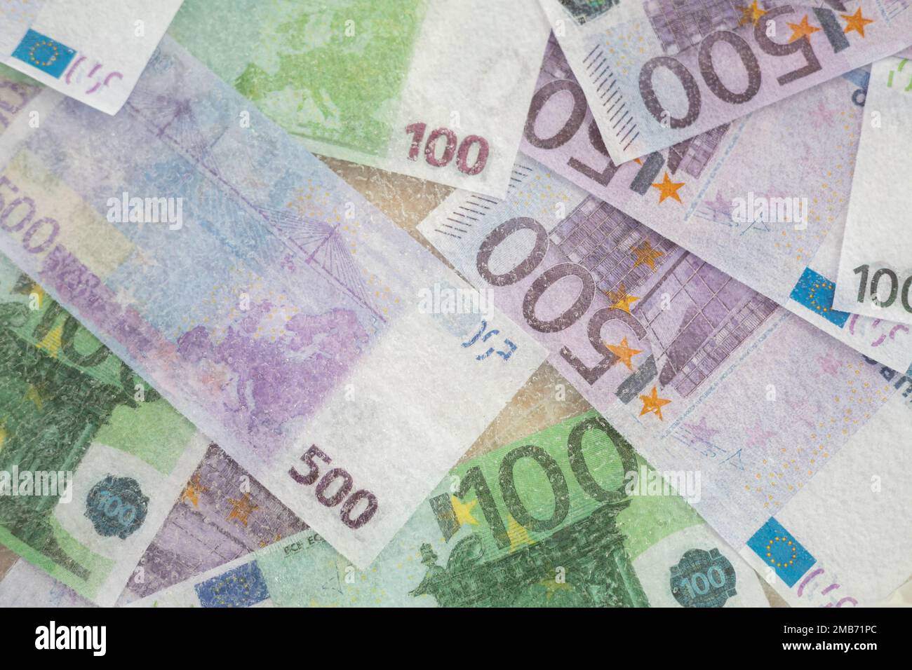 La photo floue de cent cinq cents euros est décongelée dans la glace. La monnaie européenne est gelée. Banque D'Images