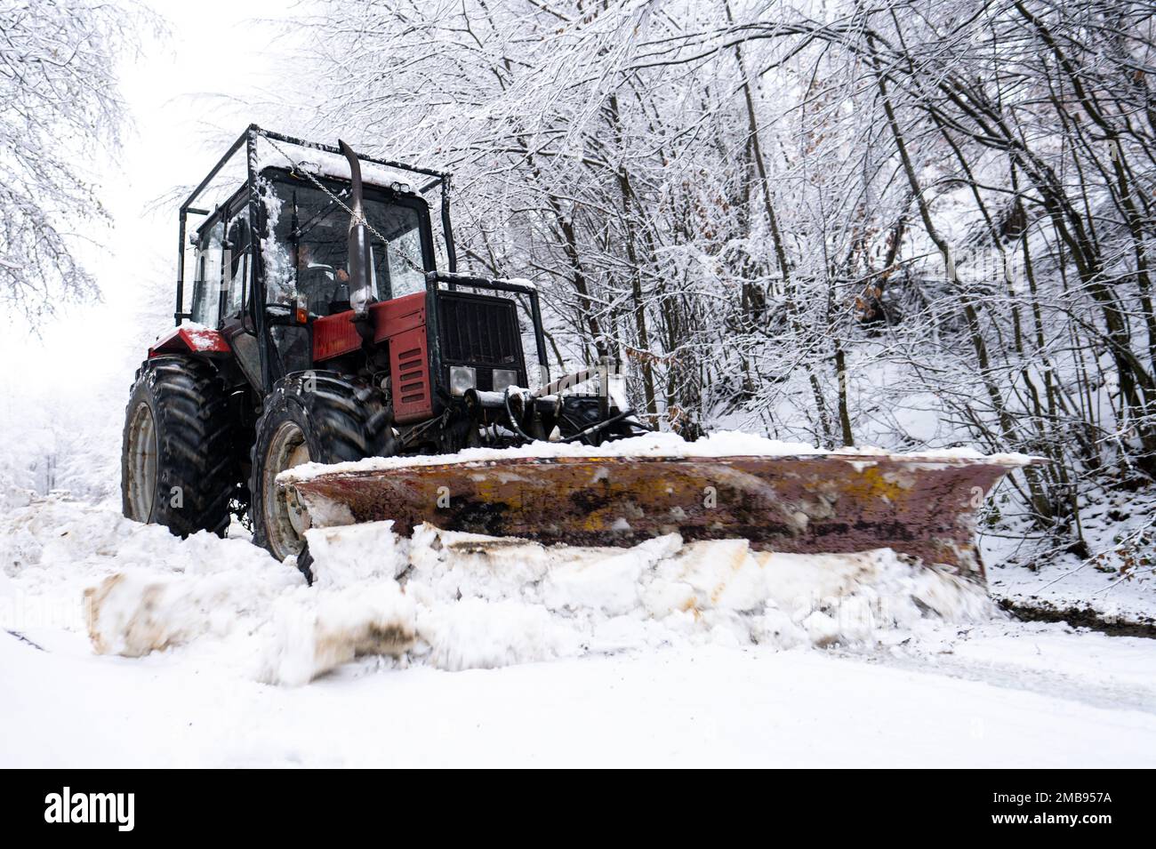 Un tracteur qui pele la neige d'une route de montagne dans les Carpates, Pologne. Banque D'Images