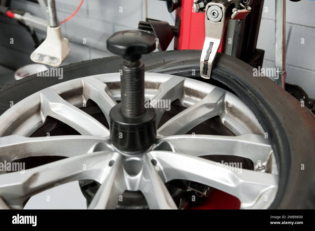 Depuis le dessus de la machine, retirer le pneu en caoutchouc de la roue pendant la journée de travail dans un atelier moderne Banque D'Images