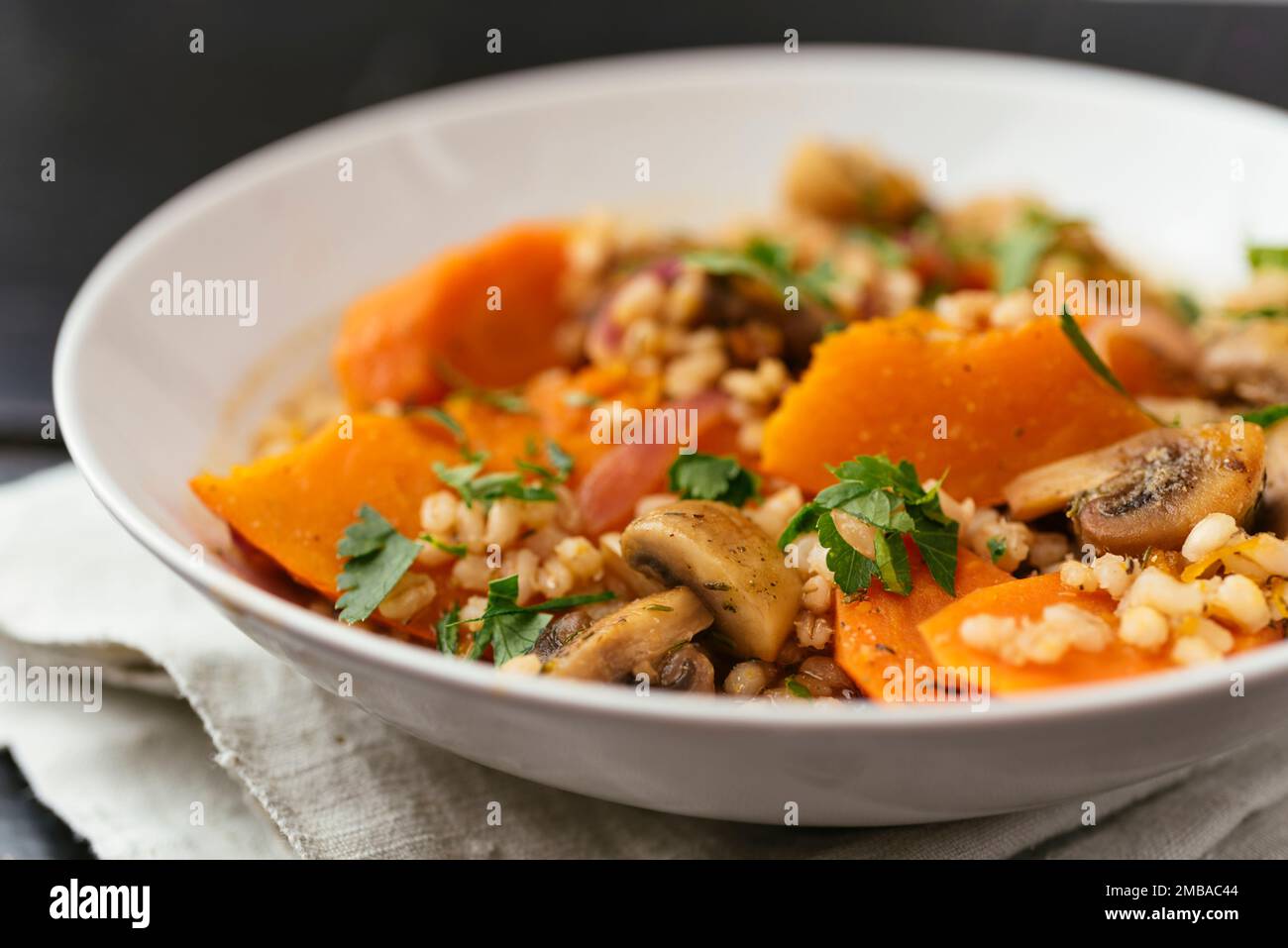 Courge d'hiver avec champignons, carottes et orge cuits au vin blanc. Banque D'Images