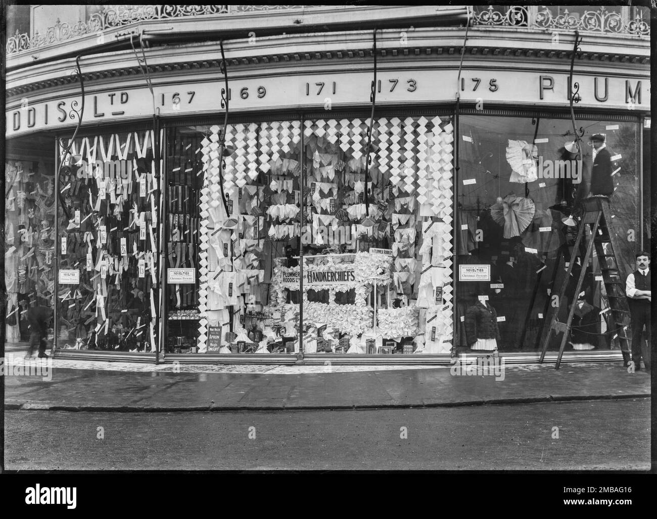 Plummer and Roddis Ltd grand magasin, 167-175 au-dessus de Bar Street, Southampton, 1909. Vue extérieure montrant l'avant de l'atelier et la vitrine du grand magasin Plummer et Roddis, avec deux hommes debout près de la fenêtre de l'atelier. La fenêtre est dotée d'un affichage de mouchoirs, y compris un tram fait de mouchoirs. Banque D'Images