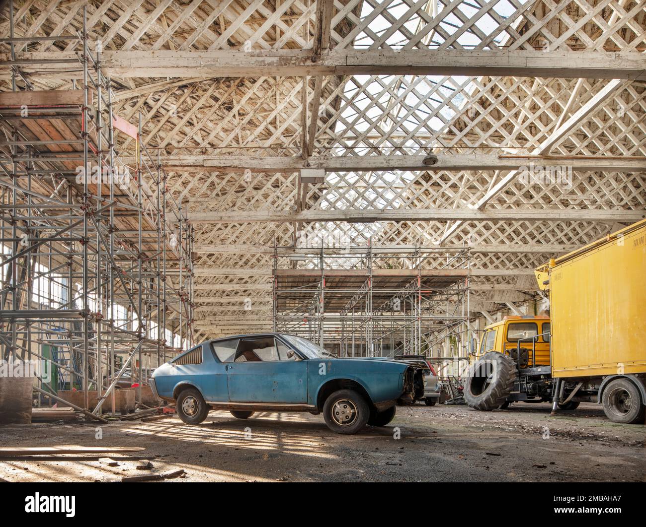 Old Sarum Airfield, Hanger 3, Laverstock, Wiltshire, 2020. Vue intérieure du hangar du sud-est à Hangar 3, Old Sarum Airfield, montrant les fermes de toit de Belfast au-dessus d'une vieille voiture au premier plan. Cette photo a été prise en insérant l'appareil photo dans une ouverture située dans une porte. Banque D'Images