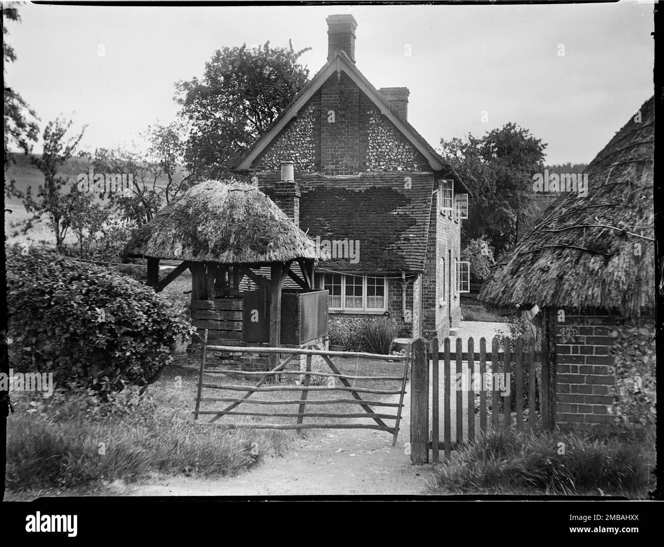 Wycombe, Buckinghamshire, 1918. Une ferme non identifiée en brique et en flanelle et un puits avec une voûte en chaume à l'extérieur. En route vers le Pink & amp ; Lily pub, Pink Road, Princes Risborough. Banque D'Images