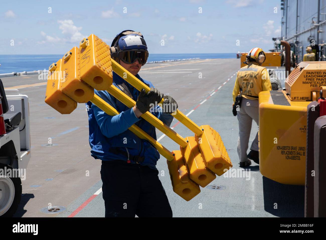 220615-N-XN177-3013 MER DES PHILIPPINES (15 juin 2022) – Airman Jesus Medina, de Chihuahua, Mexique, porte des cales d'avion sur le pont de vol du transporteur d'assaut amphibie USS Tripoli (LHA 7), 15 juin 2022. Tripoli opère dans la zone d'opérations de la flotte américaine 7th afin d'améliorer l'interopérabilité avec ses alliés et ses partenaires et de servir de force de réaction prête à l'emploi pour défendre la paix et maintenir la stabilité dans la région Indo-Pacifique. Banque D'Images