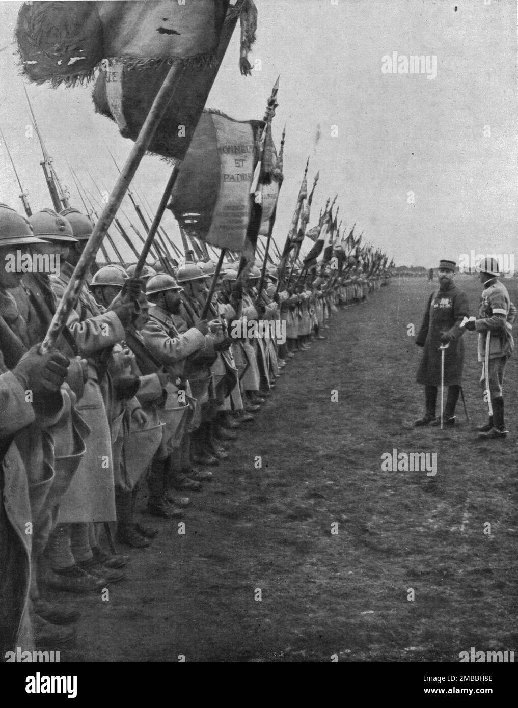 'La parade des drameaux; le général Gouraud a resuni les drameaux de tous les régiments de son armee pour saluer une divisionqui s'est distinguée a Verdun', 1916. De "Collection de la guerre IV L'Illustration Tomé CXLVII. La guerre janvier, Fevrier, Mars, avril, Mai, Juin 1916". Banque D'Images