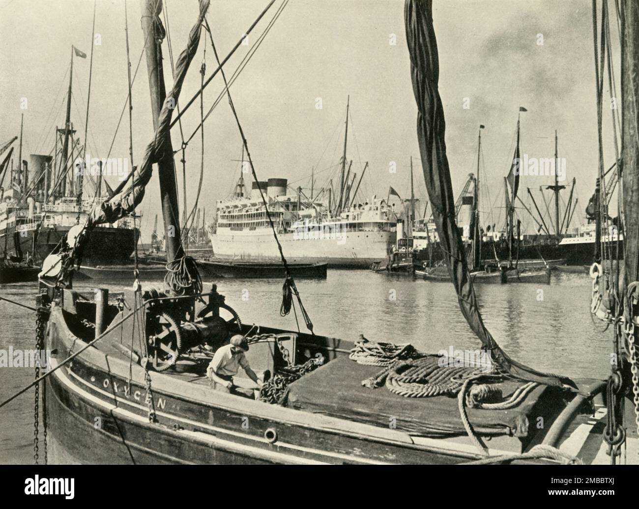 "Allez sous les ponts dans l'un des lancements de l'autorité du port de Londres et visitez Dockland" Shipping in the Royal Albert Dock, 1937. Bateaux et péniches sur la Tamise à Londres. De "la rivière Said Noble", par Alan Bell. [Administration du port de Londres, Londres, 1937] Banque D'Images