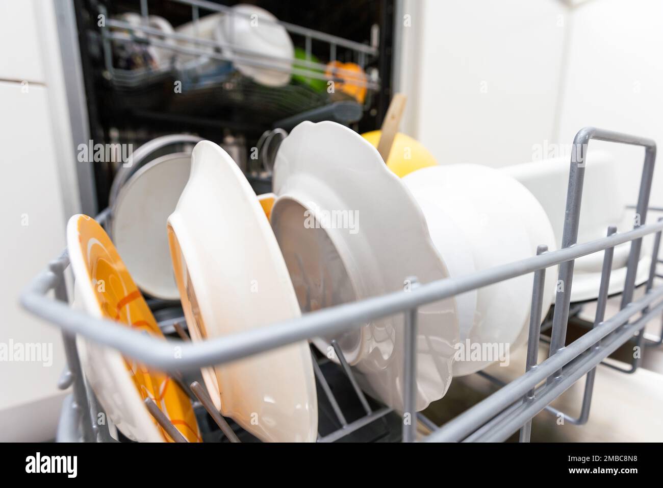 Lave-vaisselle ouvert avec vaisselle propre dans la cuisine blanche Banque D'Images