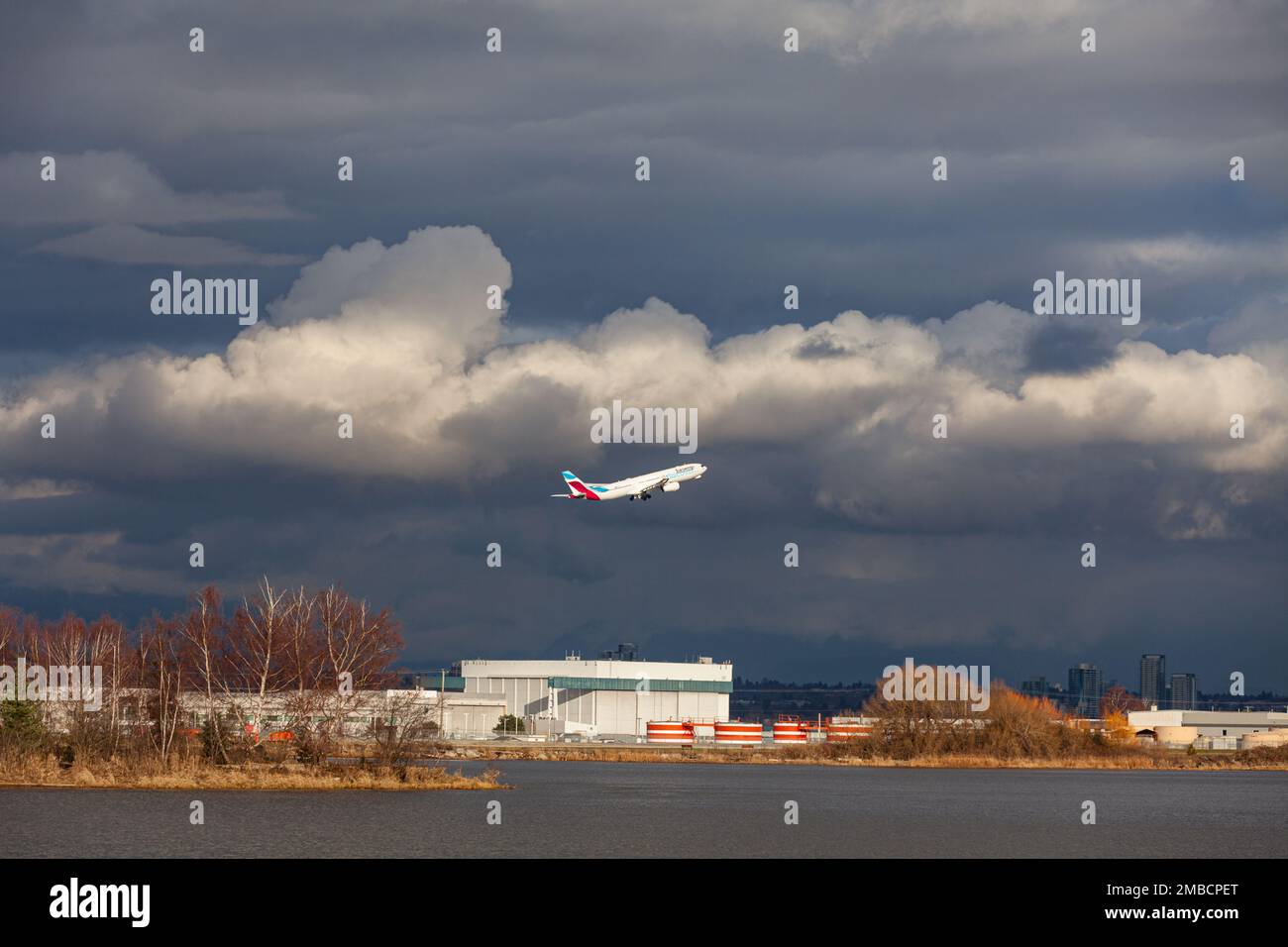 Un avion Eurowings quitte l'aéroport de Vancouver sous des nuages menaçants Banque D'Images