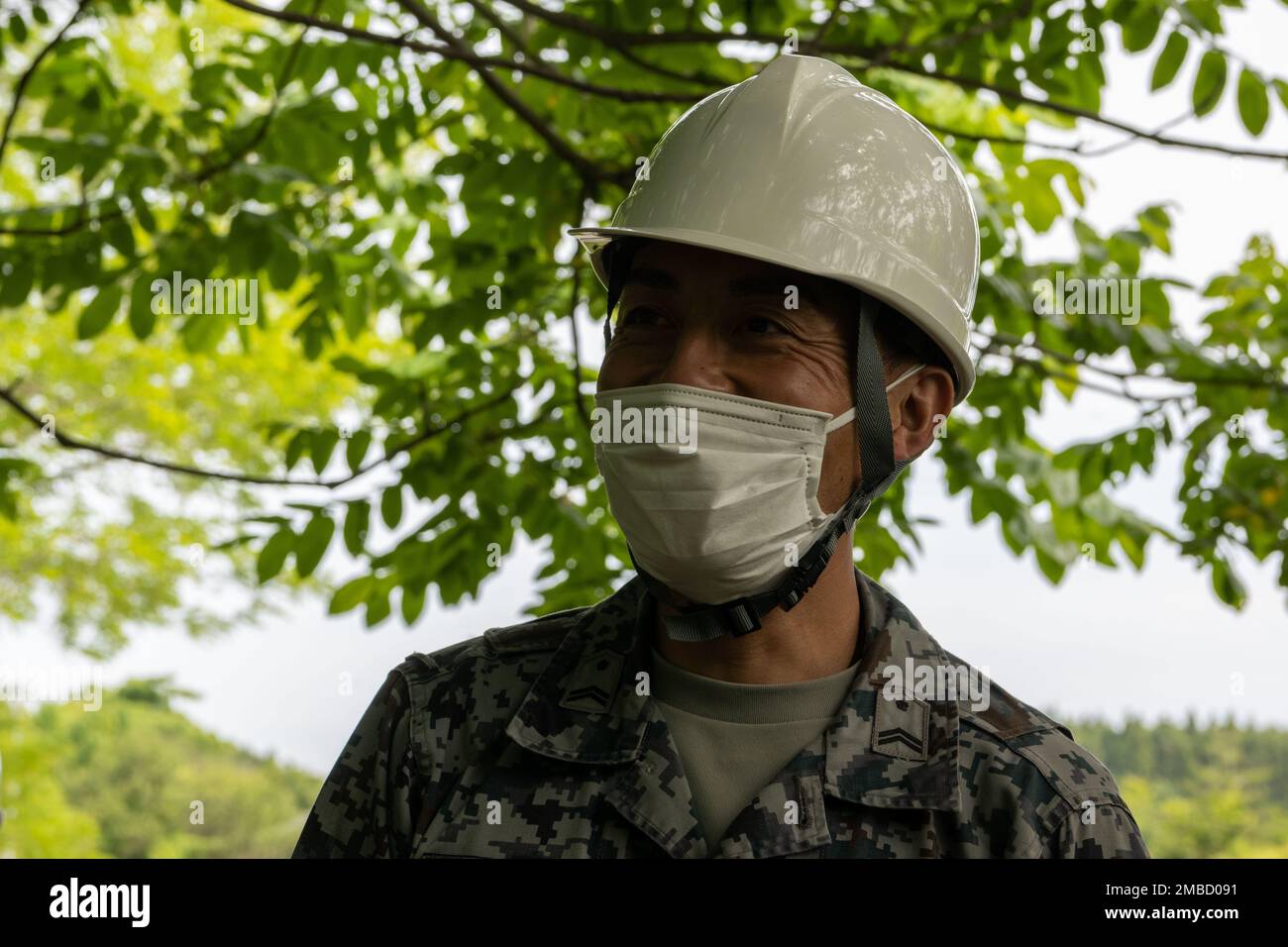 Japan Air Self-Defense Force (JASDF) Tech. Le Sgt Akashi Kikuchi, officier responsable du système d'eau et de carburant de l'escadron du génie civil de l'escadre aérienne 3rd, sourit après avoir corrigé un tuyau endommagé simulé lors de l'entraînement annuel de la Force d'urgence de l'ingénieur de la base aérienne de Misawa, au Japon, en 14 juin 2022. La formation a aidé les membres de la JASDF et de la Force aérienne à apprendre le nouveau processus et les nouvelles machines ainsi que les divers scénarios où des dommages peuvent se produire sur des parties critiques de Misawa pendant les opérations de guerre et d'urgence. Banque D'Images