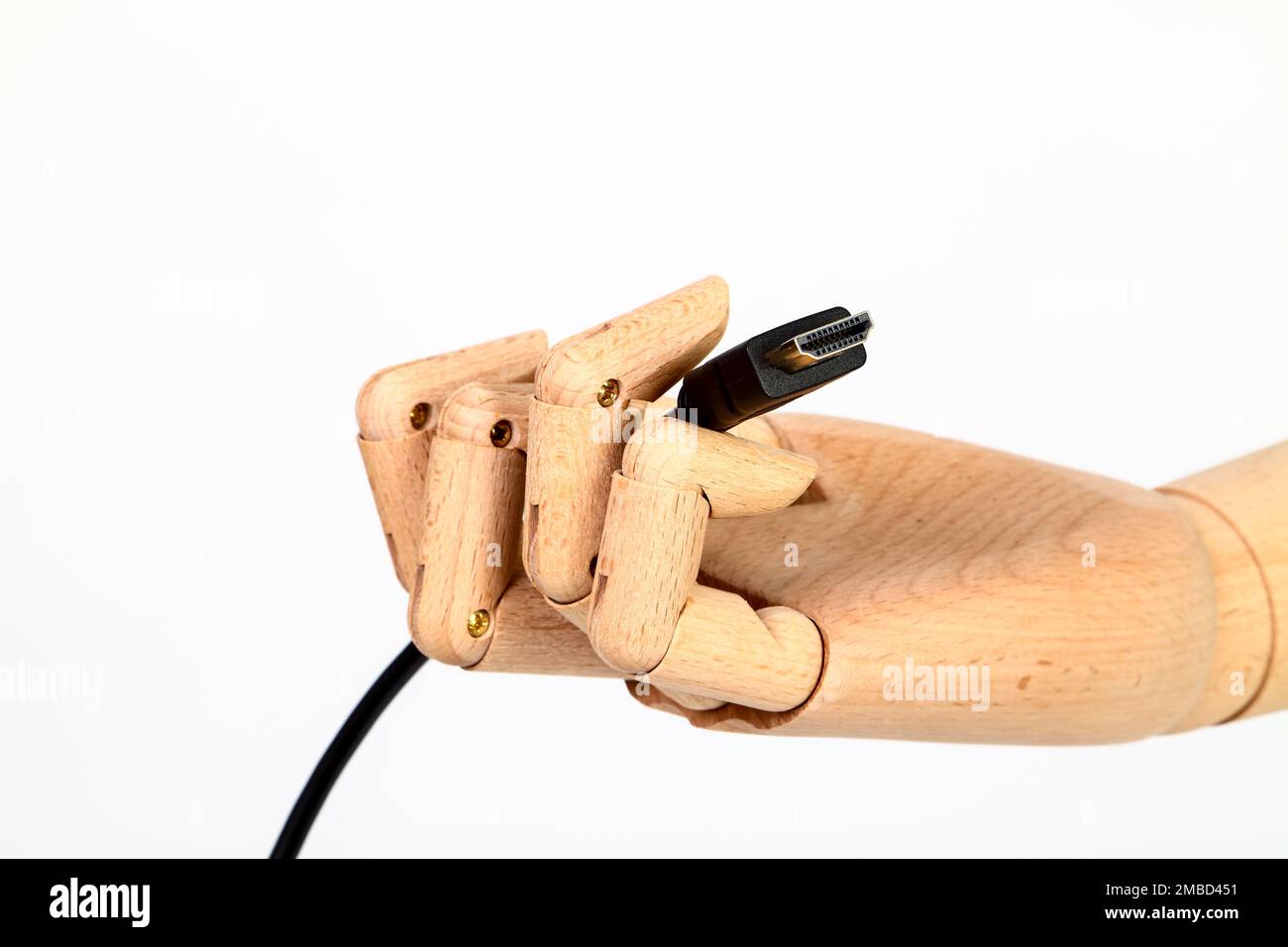 Main en bois tenant un câble HDMI isolé sur un fond blanc Banque D'Images