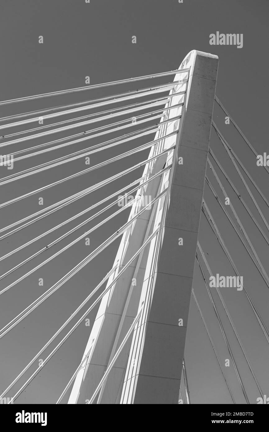 un côté sur l'image d'un pilier de pont en béton blanc et de câbles contre le ciel bleu Banque D'Images