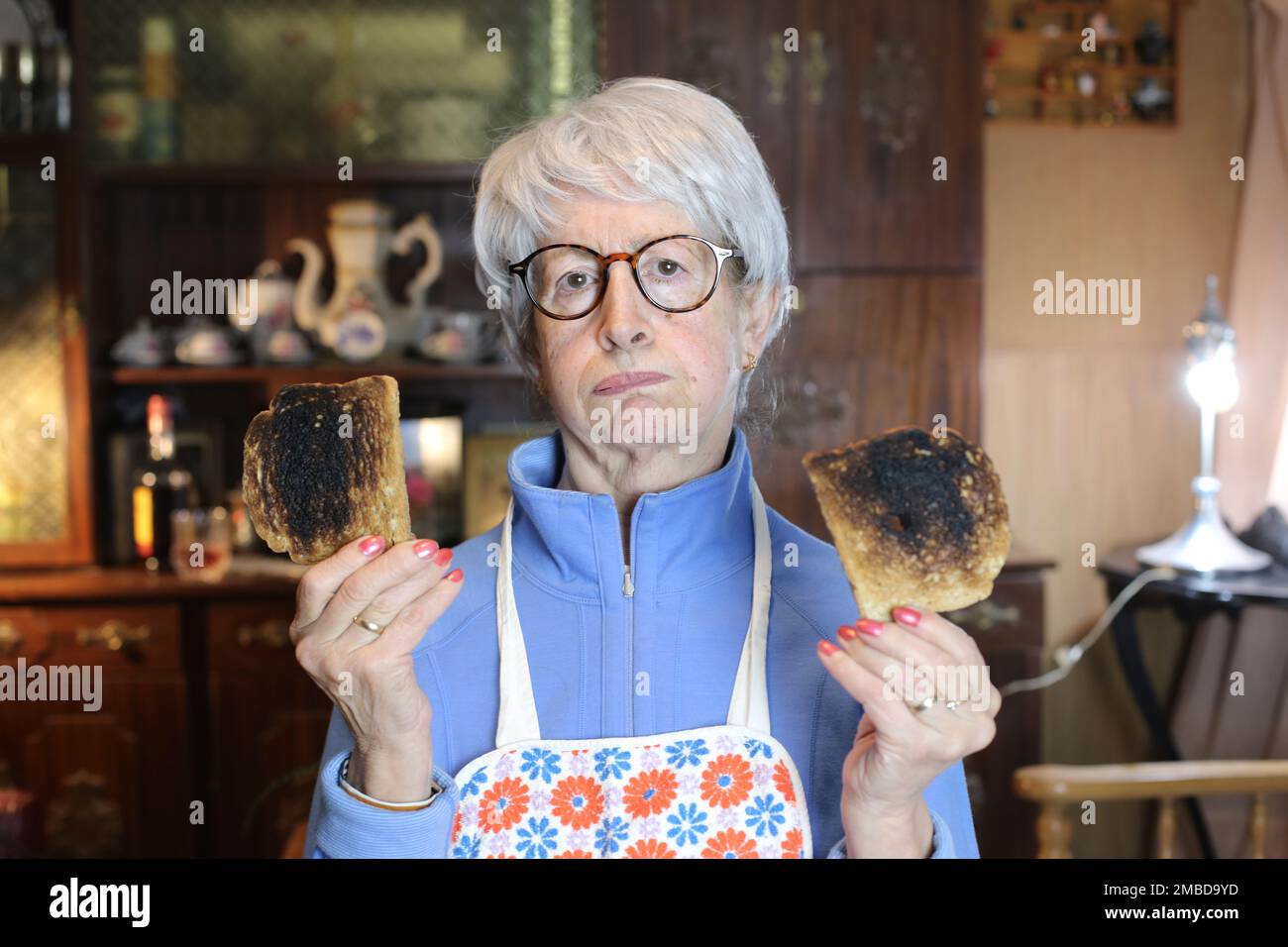 Femme âgée déçue portant des toasts brûlés Banque D'Images