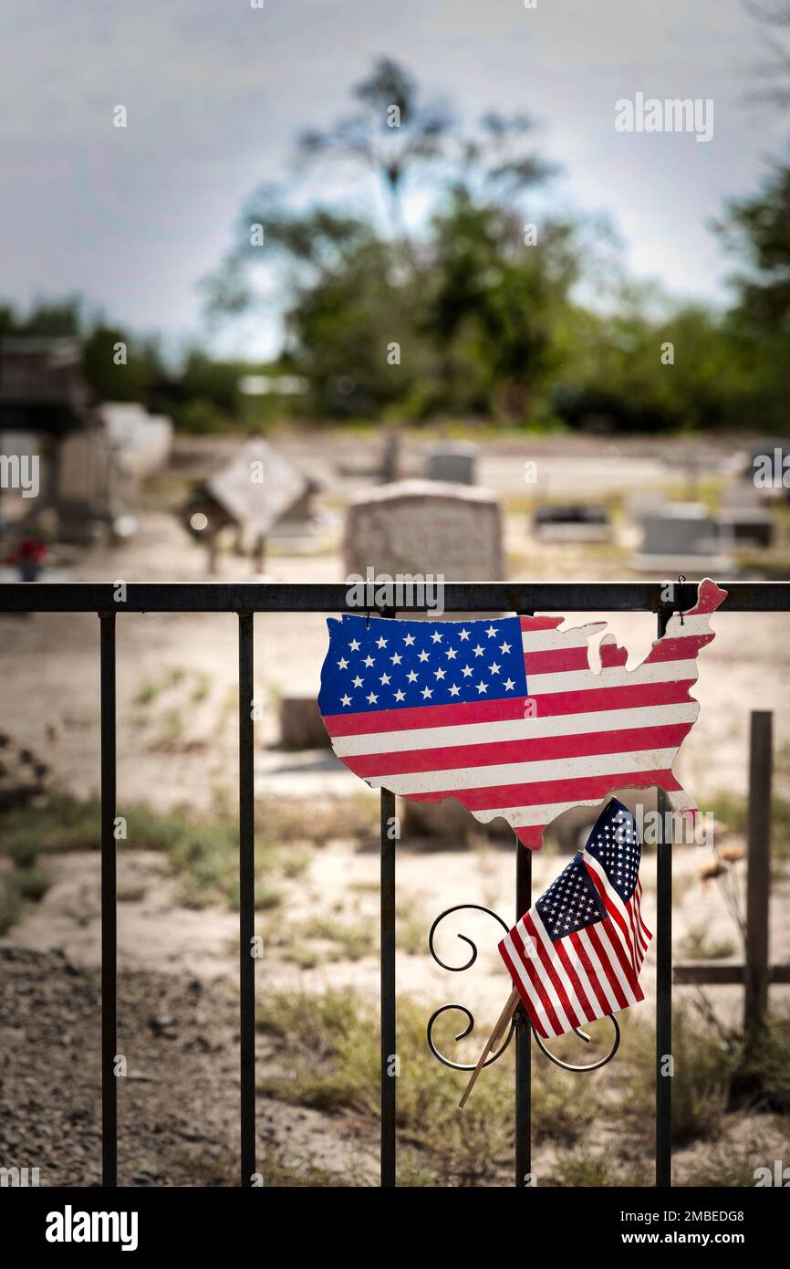 Patriotisme exposé sur une clôture à un vieux cimetière dans la zone rurale de Socorro, Texas. Banque D'Images