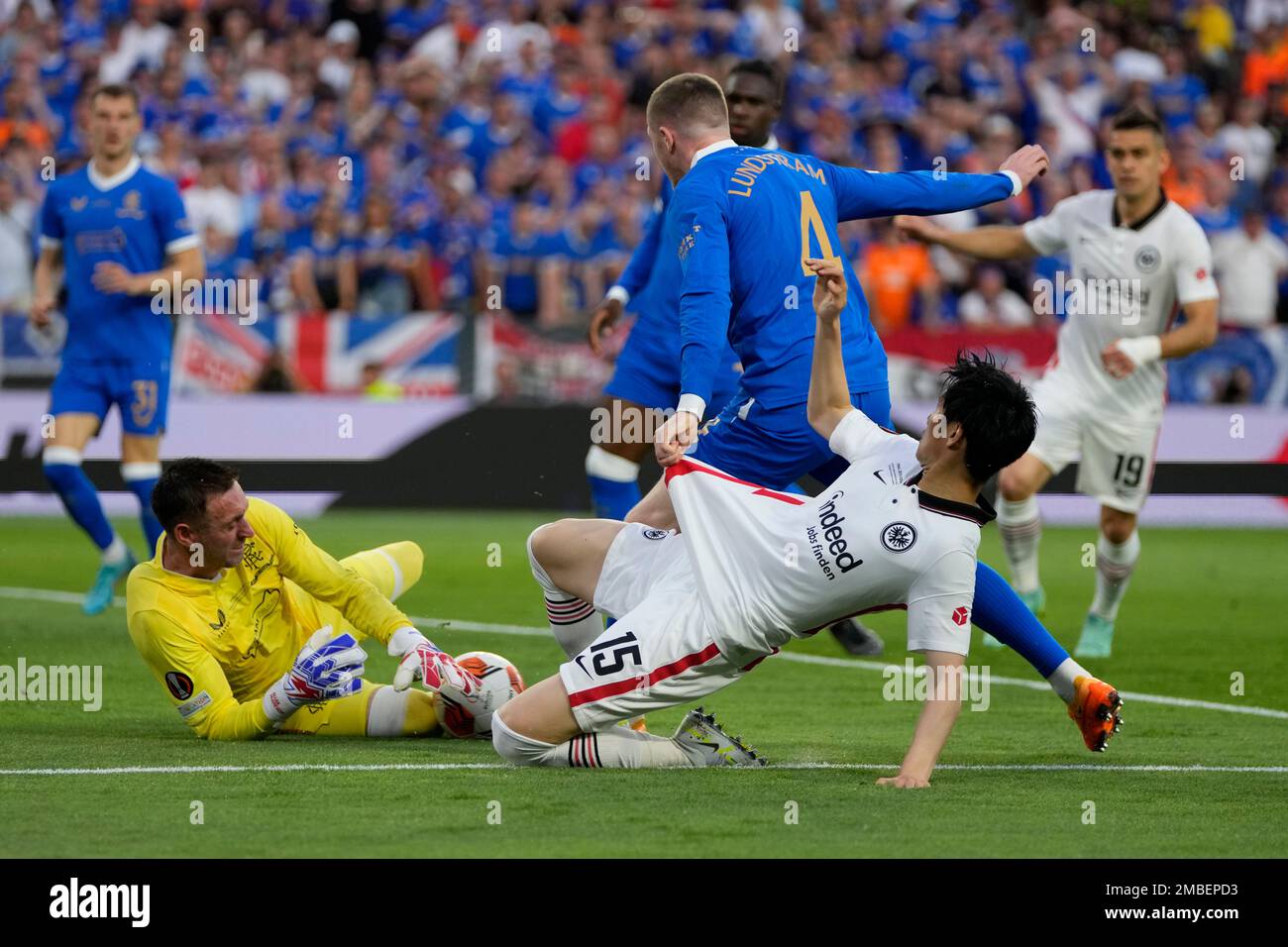 Frankfurt's Daichi Kamada, foreground, falls down in a clash with Rangers' John Lundstram, in front of Rangers' goalkeeper Allan McGregor, during the Europa League final soccer match between Eintracht Frankfurt and Rangers FC at the Ramon Sanchez Pizjuan stadium in Seville, Spain, Wednesday, May 18, 2022. (AP Photo/Manu Fernandez) Banque D'Images