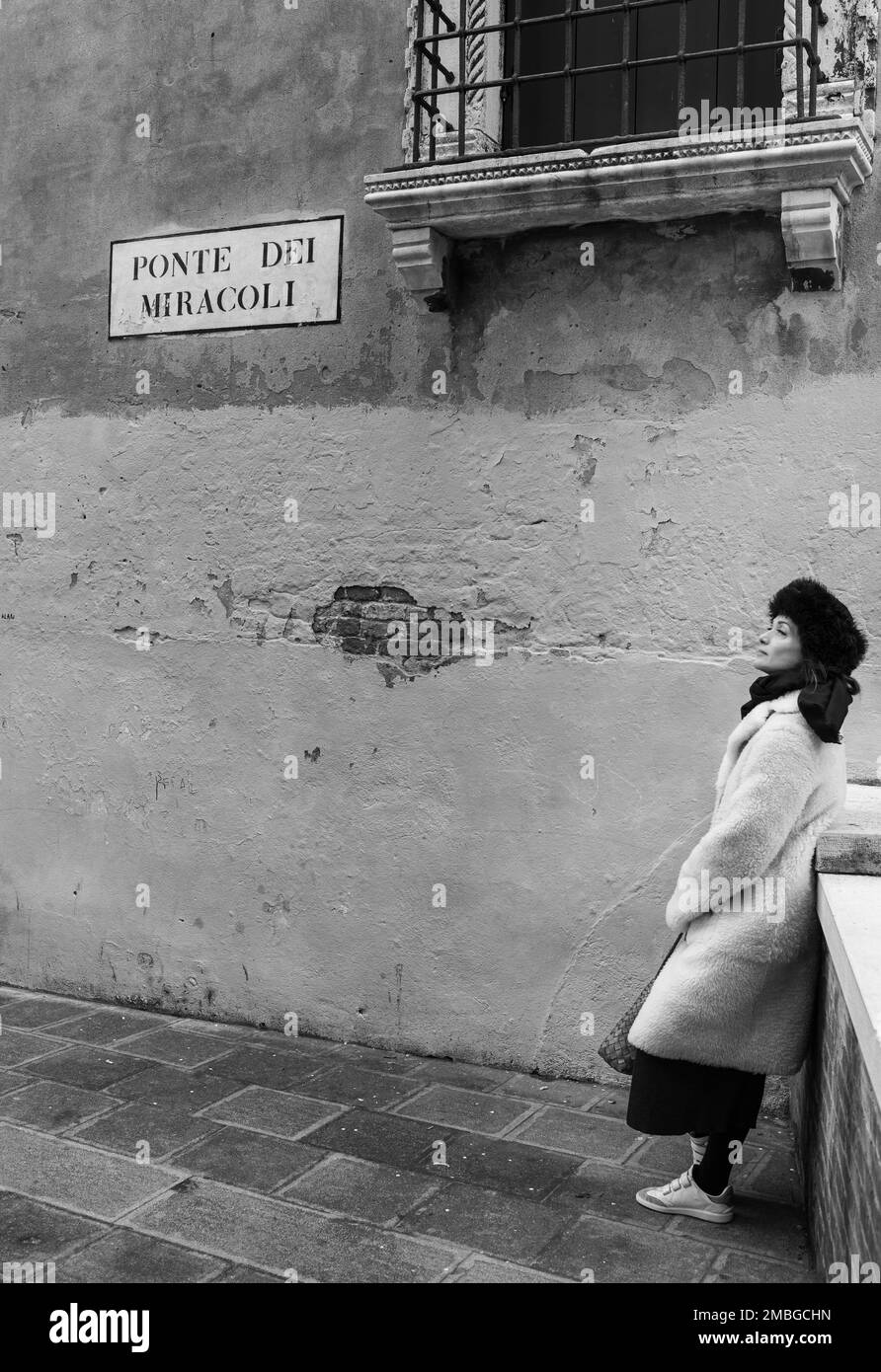 21 janvier 2023. Ponte Dei Miracoli, Venise. Une belle femme avec les yeux fermés dans un chapeau russe sur le pont des miracles dans une Venise d'hiver déserte. Banque D'Images