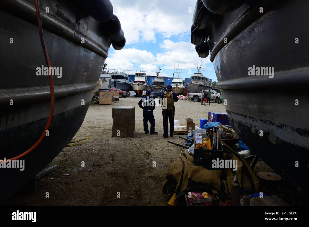 Le lieutenant Rachel Burchill (à gauche) et l'officier de Petty 3rd classe Joshua Smith (à droite), inspecteurs maritimes du Groupe de travail sur la sécurité maritime (GTSB) d'Anchorage, font une pause avant de reprendre les examens de sécurité des bateaux de pêche commerciaux à quai à Naknek, en Alaska, au 15 juin 2022. Les membres de la FCMM ont mené des examens dans la région de la baie de Bristol, 13 juin - 24, et ont porté sur l'équipement de sécurité comme les fusées éclairantes, les cartes, les signaux de navigation, les extincteurs, les balises de position d'urgence et la facilité d'entretien des combinaisons d'immersion. Chaque vaisseau ayant passé un examen à quai a reçu un autocollant. Côte des États-Unis Gu Banque D'Images