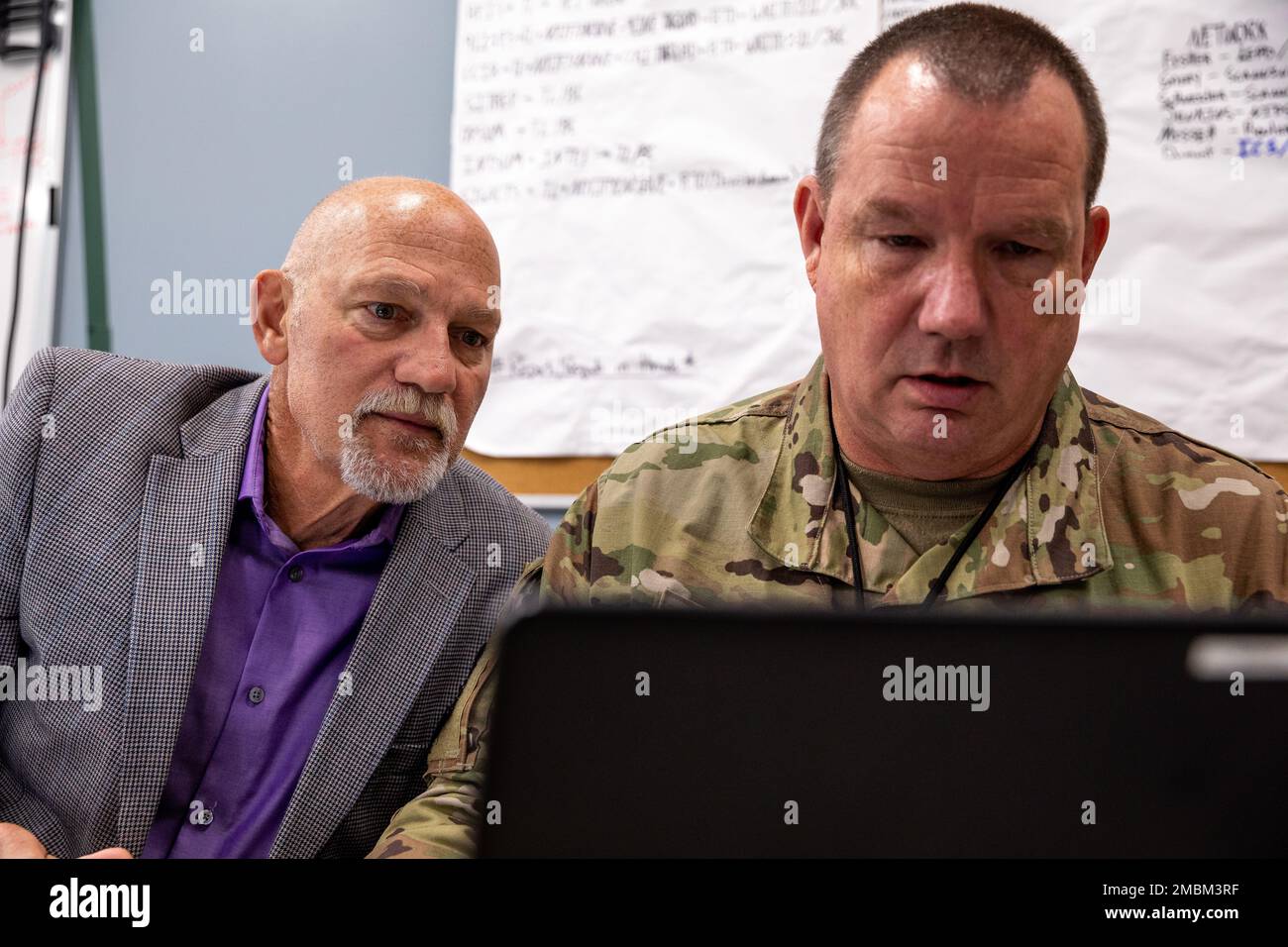 Richard Dumont, à gauche, un gestionnaire de réseau affecté à la Garde nationale de l'armée du Rhode Island, regarde l'écran d'ordinateur des États-Unis Le sergent-chef de la Force aérienne, Richard Schneider, soutien à la clientèle, 158th, escadre de chasse, Garde nationale aérienne du Vermont, Camp Net, Niantic, Connecticut, 16 juin 2022. Des soldats, des aviateurs et des civils du ministère de la Défense de toute la Nouvelle-Angleterre ont travaillé ensemble en tant que défenseurs de réseau (équipes bleues) afin de répulsion d'une cyber-attaque simulée d'un intrus de réseau (équipe rouge). Banque D'Images