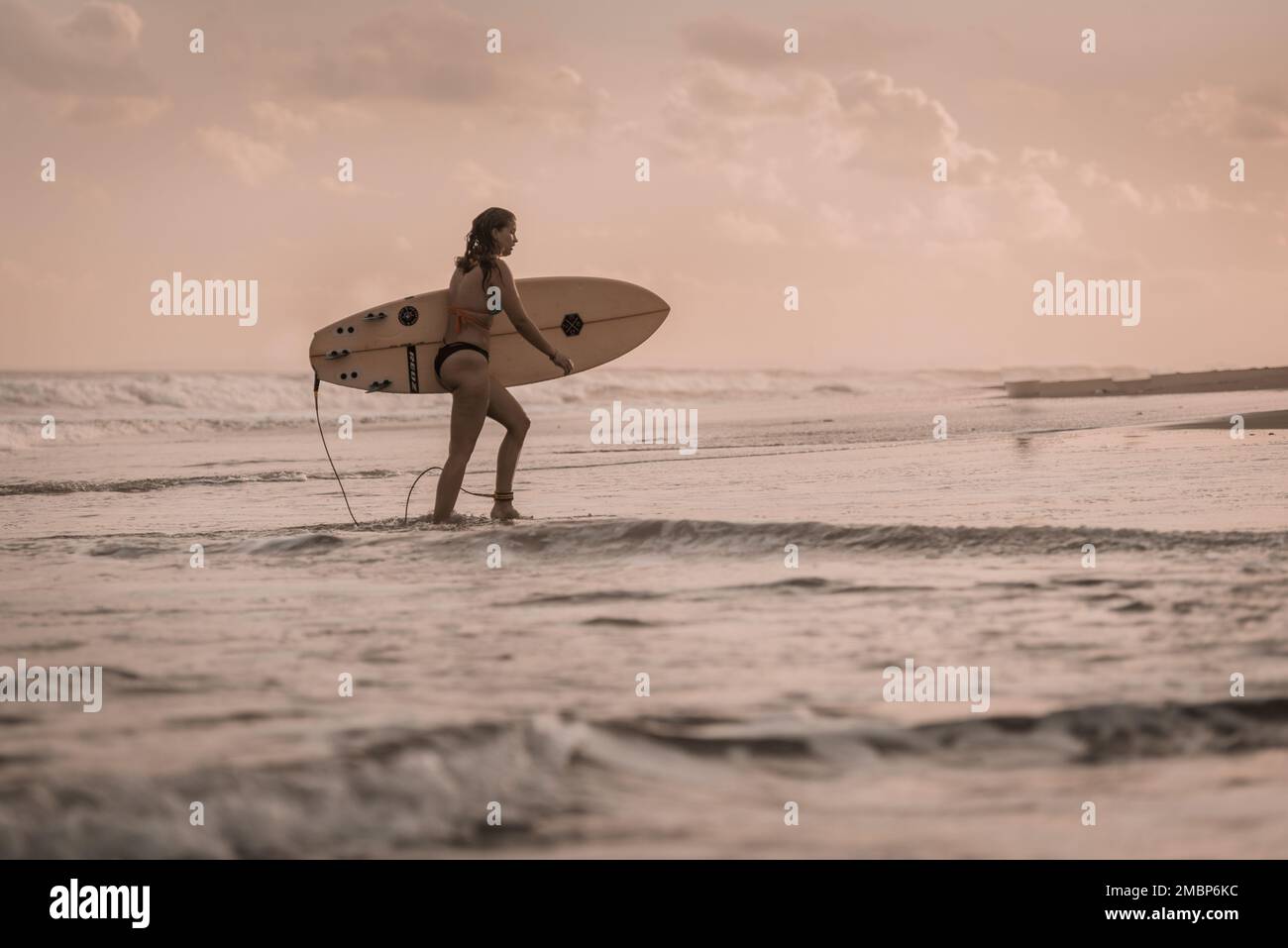 Bali, Indonésie, homme et femme tenant un surf sur la plage vagues de surf avec un surf, apprenez le surf à Kuta et Uluwatu Banque D'Images