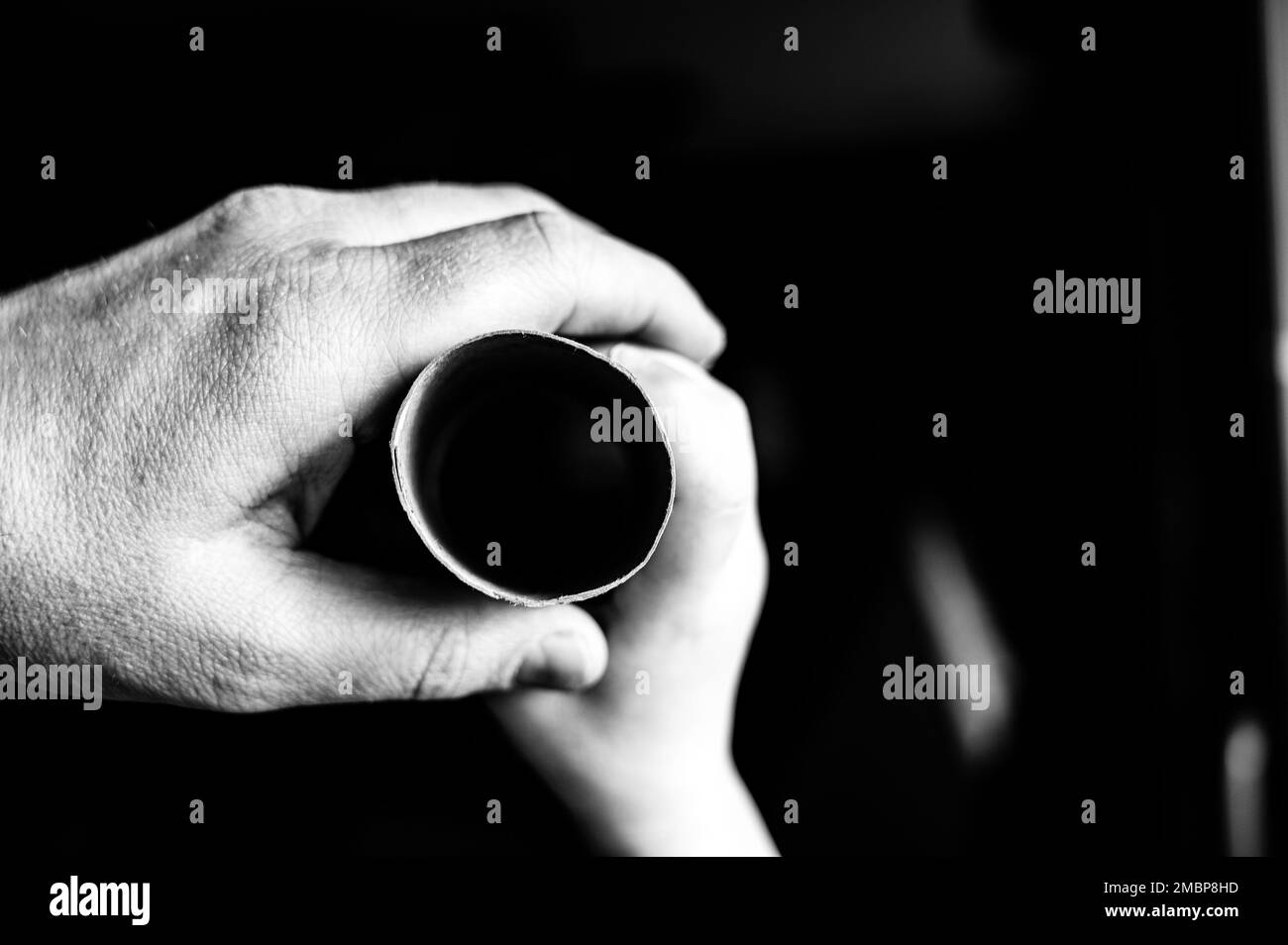 Père et enfant tenant un tube de papier de toilette en carton comme un télescope pour voir à travers pour imaginer un autre monde Banque D'Images