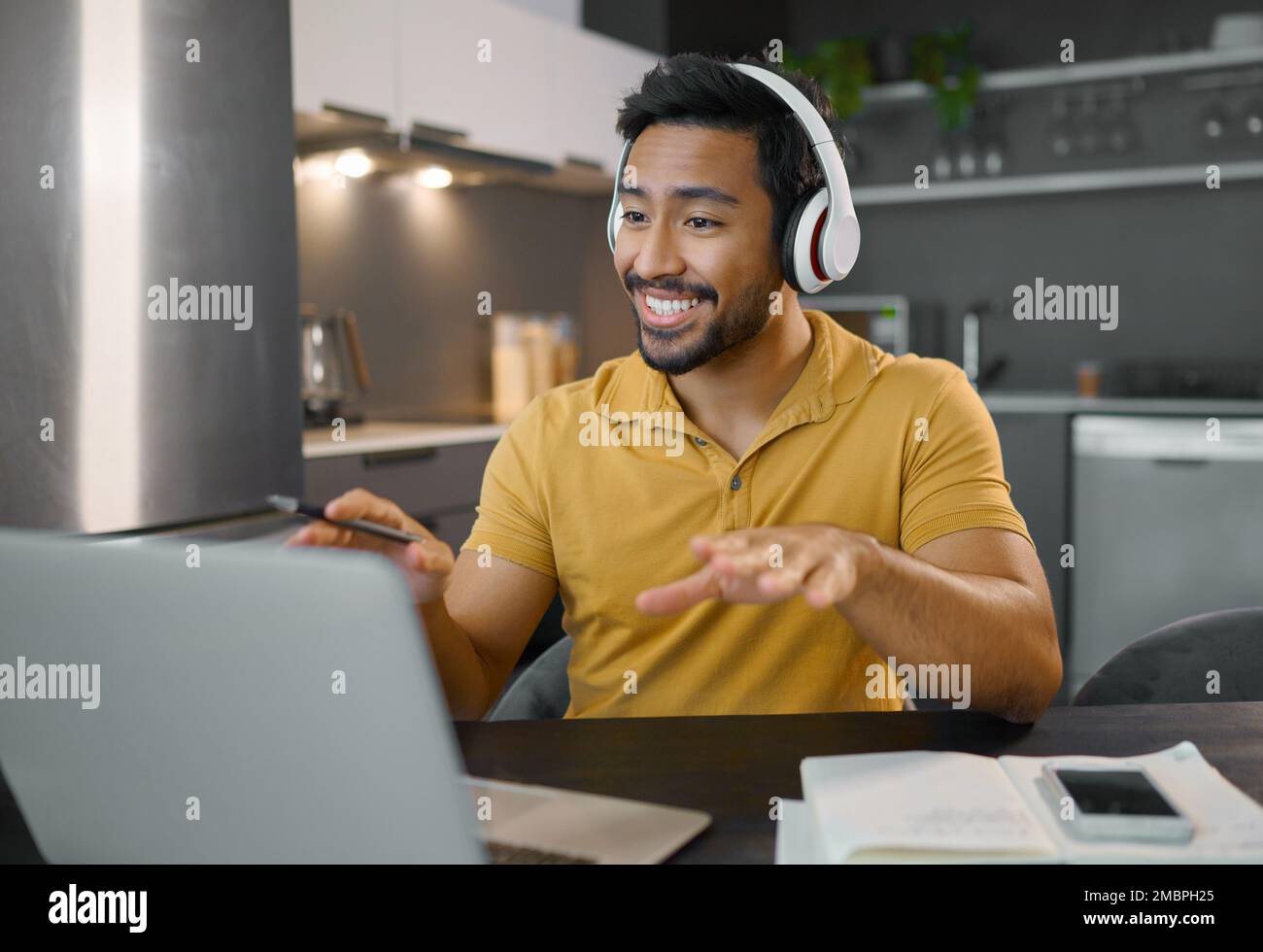 Homme heureux, casque et visioconférence sur ordinateur portable au bureau à domicile, en ligne, en conversation et en séminaire en ligne. Personne d'entrepreneur au bureau travaillant à distance Banque D'Images