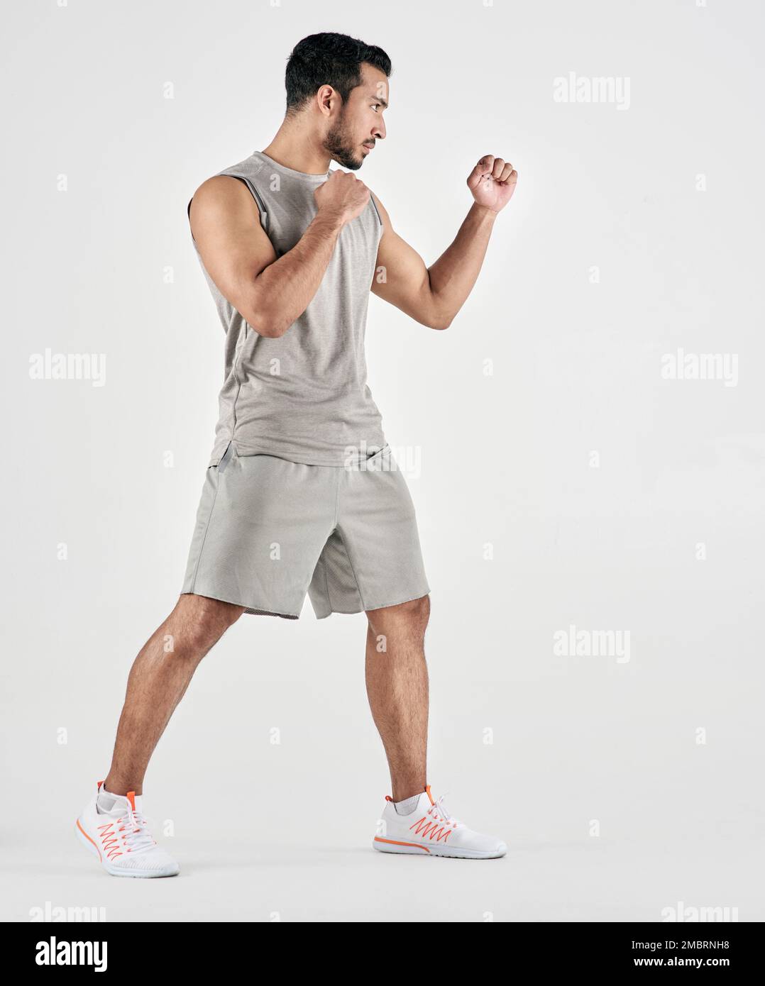 Je suis un combattant, pas une querelle. Photo en studio d'un jeune homme musclé qui se pose en position de combat sur fond blanc. Banque D'Images