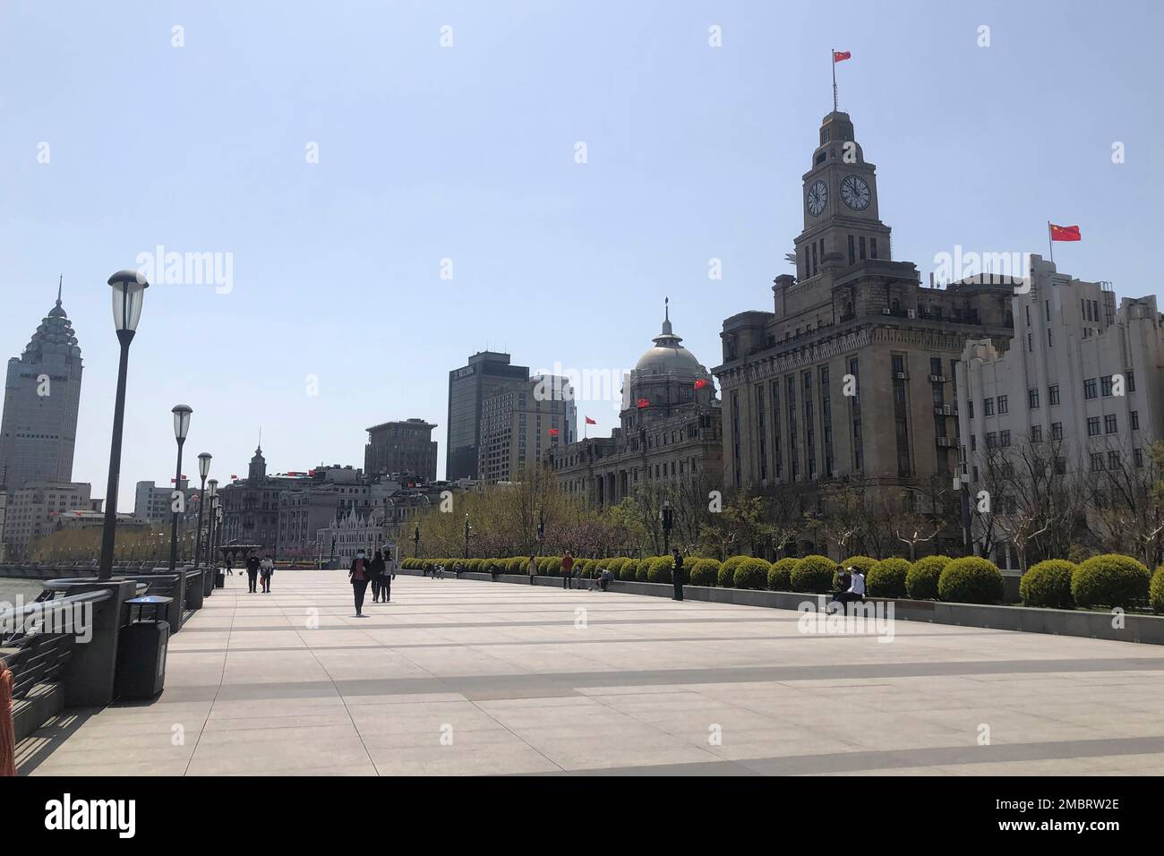 Residents visit the near empty Bund area of Shanghai, China, Tuesday, March 29, 2022. A two-phase lockdown of Shanghai's 26 million people is testing the limits of China's hard-line "zero-COVID" strategy, which is shaking markets far beyond the country's borders. (AP Photo/Chen Si) Banque D'Images