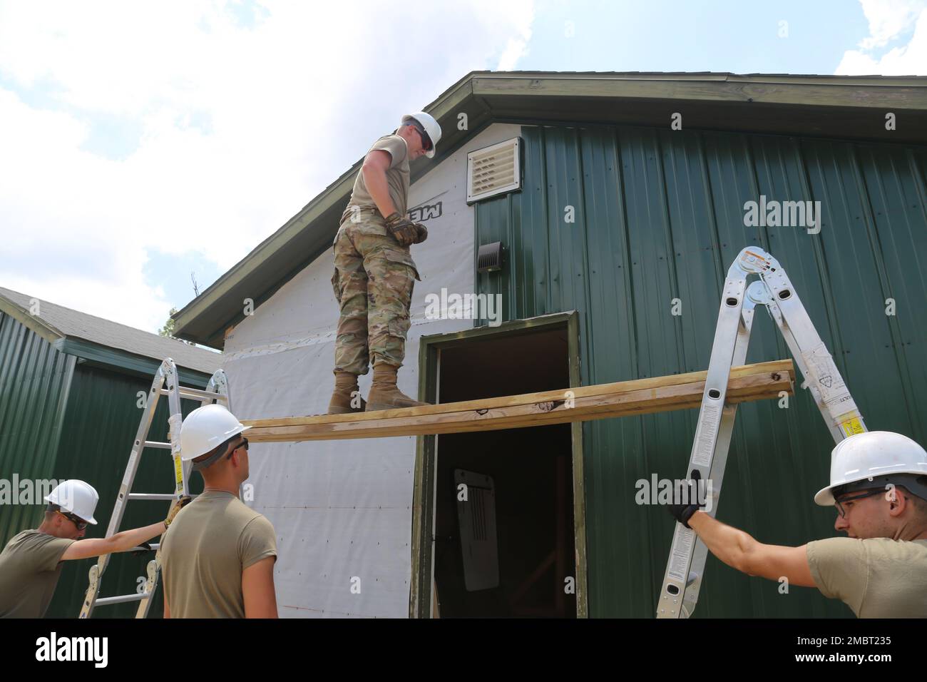 Des soldats de la Compagnie des Moines (Iowa), 389th Engineer Company de la Réserve de l'Armée de terre, travaillent sur un projet de troupes 21 juin 2022, au Camp courage de South Post à fort McCoy (Wisconsin). La compagnie a travaillé sur plusieurs projets pour améliorer le camp au cours de leur formation annuelle de 2022, y compris la mise en place d'une nouvelle voie d'évitement en métal sur de nombreux bâtiments. Les projets de troupes sont coordonnés par la Direction des travaux publics de fort McCoy et aident à améliorer l'infrastructure de l'installation tout en offrant de la formation aux unités de génie de l'Armée de terre. Banque D'Images