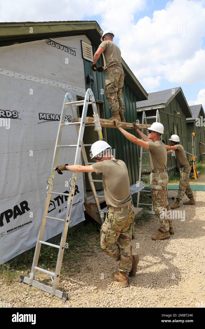 Des soldats de la Compagnie des Moines (Iowa), 389th Engineer Company de la Réserve de l'Armée de terre, travaillent sur un projet de troupes 21 juin 2022, au Camp courage de South Post à fort McCoy (Wisconsin). La compagnie a travaillé sur plusieurs projets pour améliorer le camp au cours de leur formation annuelle de 2022, y compris la mise en place d'une nouvelle voie d'évitement en métal sur de nombreux bâtiments. Les projets de troupes sont coordonnés par la Direction des travaux publics de fort McCoy et aident à améliorer l'infrastructure de l'installation tout en offrant de la formation aux unités de génie de l'Armée de terre. Banque D'Images