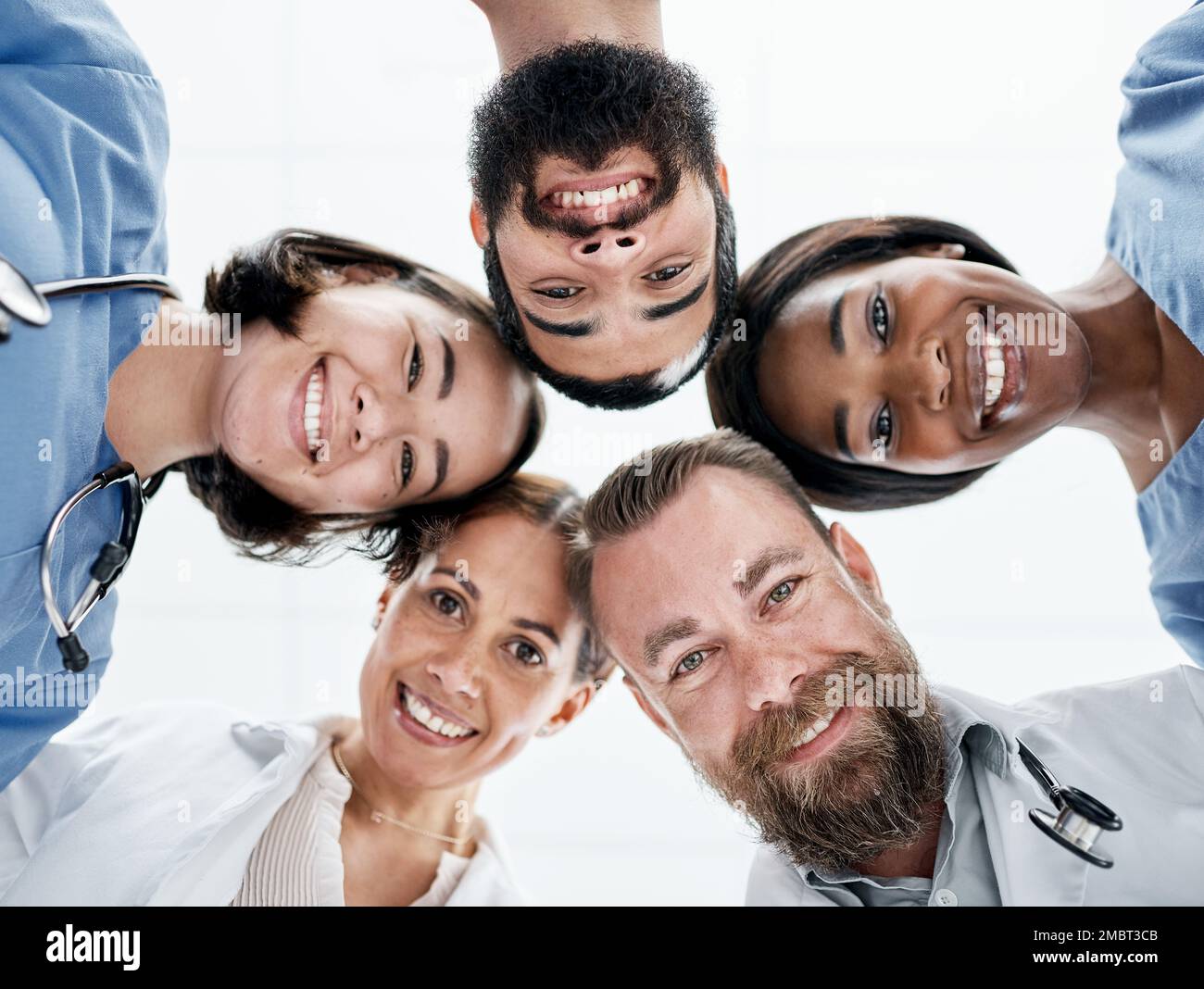 Pour vous accompagner à chaque étape. Portrait d'un groupe de médecins se joignant à leur tête dans un caucus. Banque D'Images