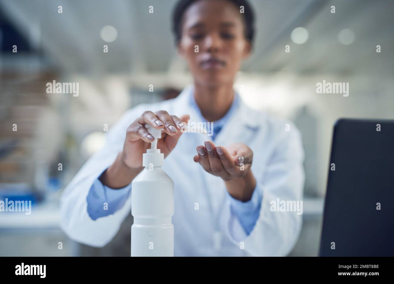 La maladie s'arrête aujourd'hui. un scientifique se désinfectant les mains tout en effectuant des recherches en laboratoire. Banque D'Images