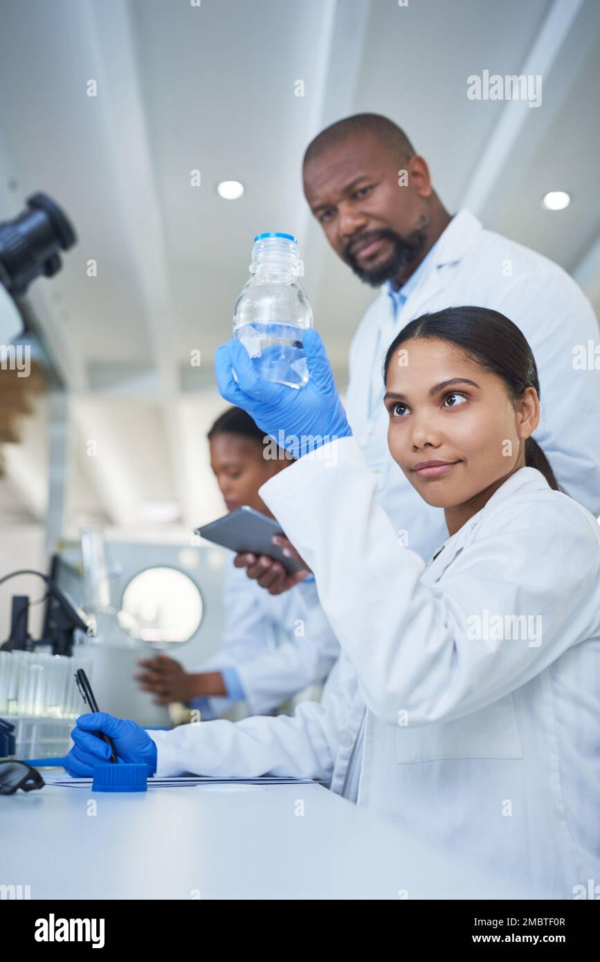 Les super-héros de la science. une jeune scientifique effectuant des recherches avec son équipe dans un laboratoire. Banque D'Images