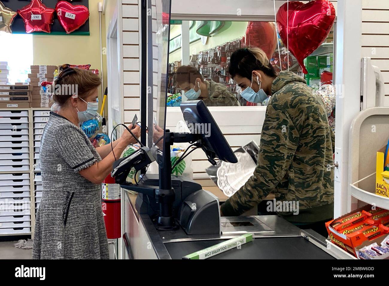 A customer wears a mask as she waits to check out at a register in a retail store in Morton Grove, Ill., Wednesday, July 21, 2021. Chicago public health officials say that COVID-19 cases caused by the delta variant are rapidly increasing in the city, and that by next month the strain will likely be the dominant form of the virus in the city. (AP Photo/Nam Y. Huh) Banque D'Images